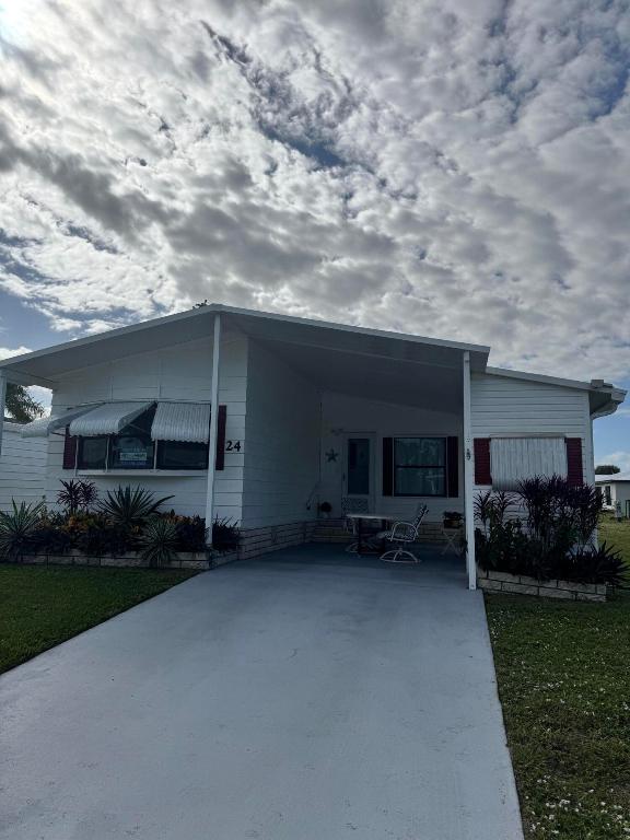 Lovely 2-bedroom 2-bath home with LAKE VIEW. Home is in the desirable 55+Spanish Lakes Country Club community. No carpet. NEW LAMINATE FLOORS. NEW WATER HEATER 2025.  Split floor plan. Florida room with a deck off the back of the home for enjoying morning coffee or evening cocktail, looking out at the beautiful lake view.  Lawn care, trash removal, and golf are included in lot rent. 2 pools, tennis, pickleball, bocceball, and shuffleboard. clubhouse and much more.