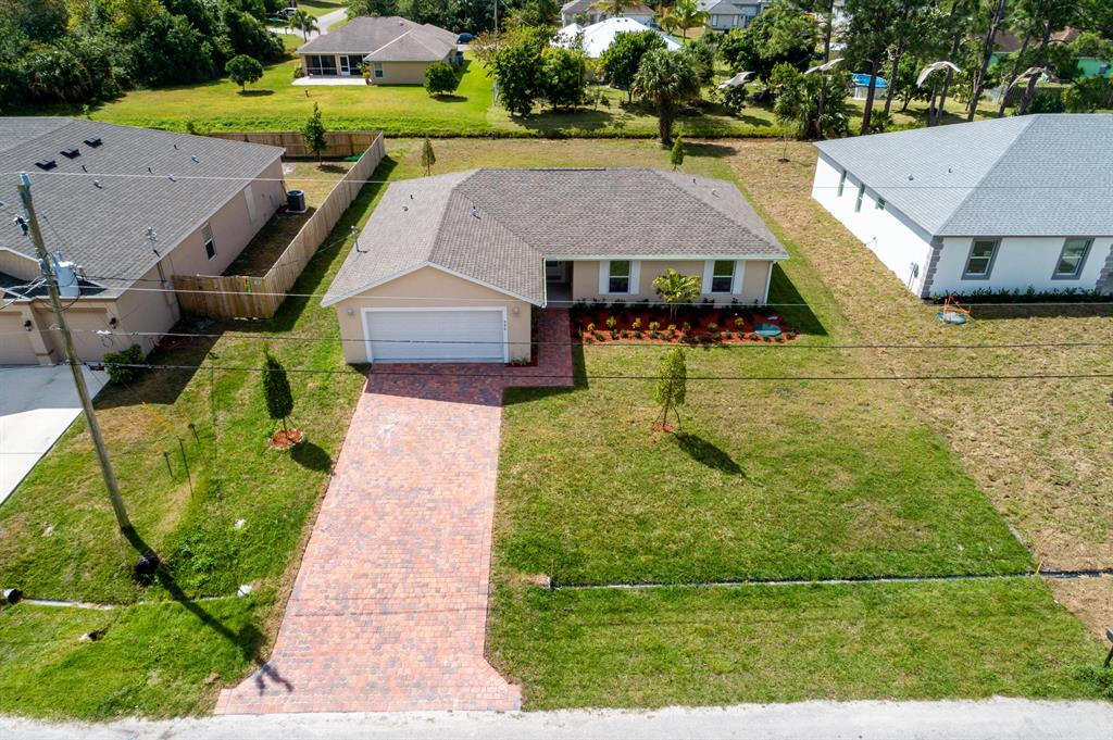 This custom built home features a wide open floor plan with Granite Kitchen, Soft Close Wood Cabinets, Stainless Appliances, vaulted ceilings and porcelain tile floors, paver driveway. Buyers will appreciate the expanded floorplan w/large Primary Bedroom & walk-in closets and Luxurious Primary Bath with dual sinks, Separate Shower and Garden Tub!!! Home has HURRICANE IMPACT WINDOWS THROUGHOUT & IS CONCRETE BLOCK CONSTRUCTION ! Inside Laundry room! Professionally designed including wood laminate flooring in bedrooms, tiled showers, ceiling fans in all bedrooms, vaulted ceilings and more. Nice backyard ready for true South Florida Indoor/Outdoor Living. Entertain your family, friends and guest. Excellent location close to shopping, schools, I 95 and Fl Turnpike.