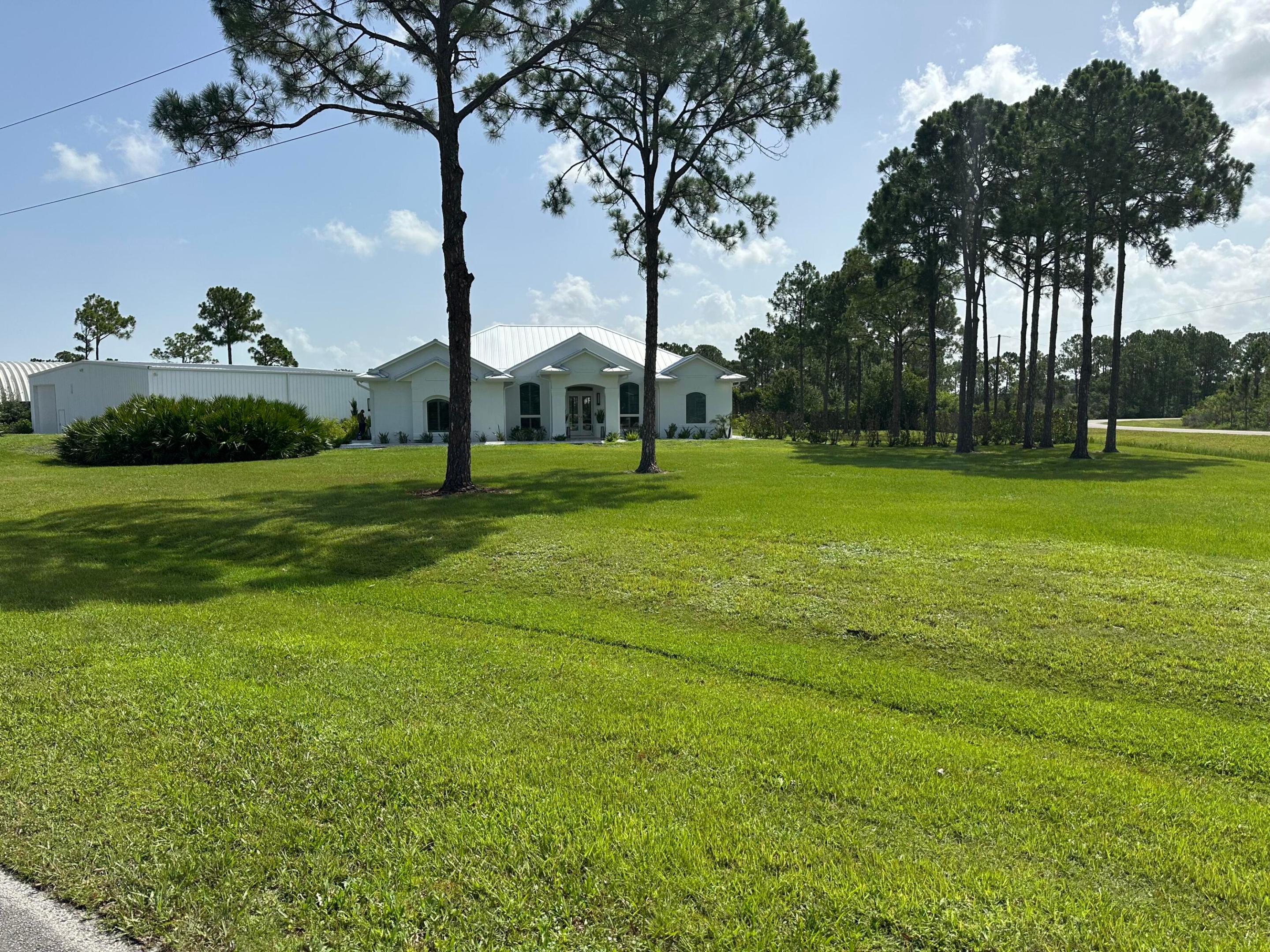 Live the ultimate fly-in lifestyle in the exclusive Treasure Coast Airpark, a premier aviation community featuring its own private runway. Situated on over 2 acres with direct runway access, this exceptional 3-bedroom, 3-bathroom estate offers the perfect blend of luxury, privacy, and functionality. The impressive 60' x 60' air-conditioned airplane hangar with epoxy floors, own bathroom and separate septic system provides ample space for your aircraft, vehicles, RVs, workshop, or hobby collection, allowing you to taxi from your property directly to the community's private runway. The home has been thoughtfully updated with a 2024 metal roof and features a well-appointed kitchen equipped with premium Thermador appliances, including a  36-inch gas range with electric oven and a built-in refrigerator. A GE washer and gas dryer are also included for added convenience. Whether you're an aviation enthusiast or simply looking for an extraordinary property with room to spread out, this rare estate offers an unmatched opportunity to enjoy luxury living in one of Florida's premier fly-in communities.