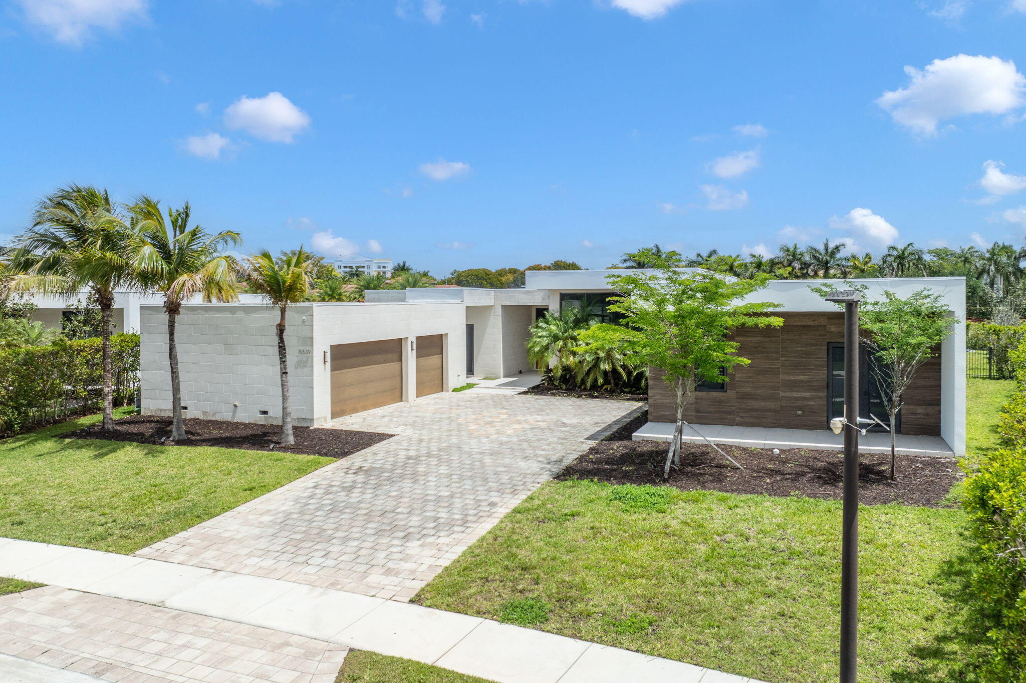 Tucked within the exclusive gates of Botaniko Weston, where modern architecture meets the serenity of nature, there is a home that doesn't simply exist, it unfolds like a quiet masterpiece. Set on one of the most coveted, and largest, lots in the community, spanning an impressive 27,362 square feet, this one-story residence stretches gracefully across 7,293 square feet of refined living. From the moment you arrive, the clean lines and bold architectural presence hint at what lies within: a home designed not just to impress, but to elevate everyday living.  Step inside, and space reveals itself in breathtaking fashion. Soaring 20-foot ceilings draw your eyes upward, while natural light pours in, reflecting off sleek finishes and framing tranquil lake views that follow you from room to room. The layout flows effortlessly, open, expansive, and intentional, creating a seamless connection between living, dining, and gathering spaces. At the heart of the home, the kitchen becomes a statement of both design and function. Outfitted with world-renowned appliances, Wolf, Sub-Zero, and a built-in Bosch coffee system, it invites everything from quiet morning rituals to vibrant evenings filled with conversation. Every detail has been curated for those who appreciate precision, beauty, and ease. Six beautifully appointed bedrooms, along with a private staff suite, offer comfort and privacy for both family and guests. Each of the 7.5 bathrooms feels like a personal retreat, echoing the home's modern elegance with clean lines and luxurious finishes. And then... the outdoors becomes an extension of the experience. The oversized pool stretches across the backyard like a private resort, reflecting the sky and the water beyond. An expansive outdoor kitchen sets the stage for unforgettable gatherings, weekend celebrations, sunset dinners, or simply the quiet luxury of living well. Thoughtful additions, like electronic window screens and even an in-ground trampoline, bring together sophistication and play in a way that feels effortless. But what truly defines this home is its setting. Living in Weston is about more than just a beautiful address, it's a lifestyle. Known for its tree-lined streets, top-rated schools, and a sense of calm rarely found in South Florida, Weston offers a balance between elegance and ease. From morning walks through peaceful neighborhoods to evenings at nearby parks, golf courses, and the vibrant Weston Town Center, with its dining, boutique shopping, and community events, life here feels curated, intentional, and connected. And within Weston, Botaniko stands apart. A newer, architecturally distinct enclave inspired by modern design, it attracts those who seek privacy, innovation, and a home that reflects a global sense of style. This is more than a property. It's a place where design meets lifestyle... Where every space invites connection... And where arriving home feels like stepping into something truly extraordinary.
