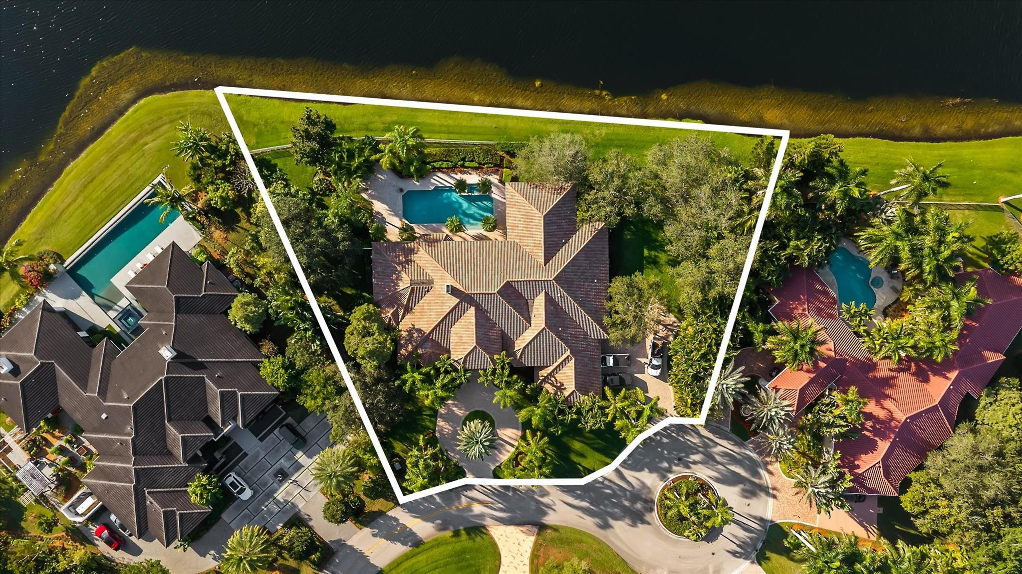 Tucked at the end of a quiet cul-de-sac in guard-gated Windmill Ranch Estates, this rare lakefront opportunity sits on nearly 1 acre (.95) with serene water views and exceptional privacy. Offering approx. 6,025 SF, the home features 5 bedrooms, 5 full baths, 2 powder rooms, a game room or theater, dedicated office, and a flex suite off the primary bedroom ideal for a nursery, gym, or private retreat. Enjoy a covered outdoor kitchen and expansive entertaining areas overlooking the lake, perfect for everyday living and sunset gatherings. A true blank canvas in one of Weston’s most coveted communities, known for exclusivity, top schools, and outstanding quality of life. A rare chance to create a dream home and lasting legacy in a trophy location. At the end of a peaceful cul-de-sac, beyond the gates of Windmill Ranch Estates, life unfolds at a different pace. Mornings begin with still water reflecting the sky, children waking to quiet surroundings, and the sense that the day ahead does not need to be rushed. Set on nearly an acre of land, this lakefront property offers rare privacy and a feeling of openness that is increasingly hard to find.With over 6,000 square feet, the home is generous yet intimate, designed to adapt. Five bedrooms and multiple living areas allow everyone their own space, while still bringing the household together. The game room becomes a hub for laughter and memories, the office a place of inspiration and productivity. The private flex room off the primary suite transforms with time, from nursery, to fitness studio, to personal retreat, shaping itself around your life's chapters.Outside, the home truly comes alive. The covered outdoor kitchen and expansive gathering areas invite long weekends, effortless entertaining, and evenings spent watching the sun melt into the lake. Children play freely, conversations linger, and milestones are celebrated against a backdrop that never grows old.Windmill Ranch Estates is not simply a community, it is a statement. Known for its exclusivity and timeless appeal, it offers a lifestyle rooted in privacy, prestige, and connection. Combined with Weston's renowned schools, safety, and quality of life, this property stands as more than a home. It is an opportunity to invest in moments that matter, to build something meaningful, and to create a legacy in one of the most sought-after settings in South Florida.