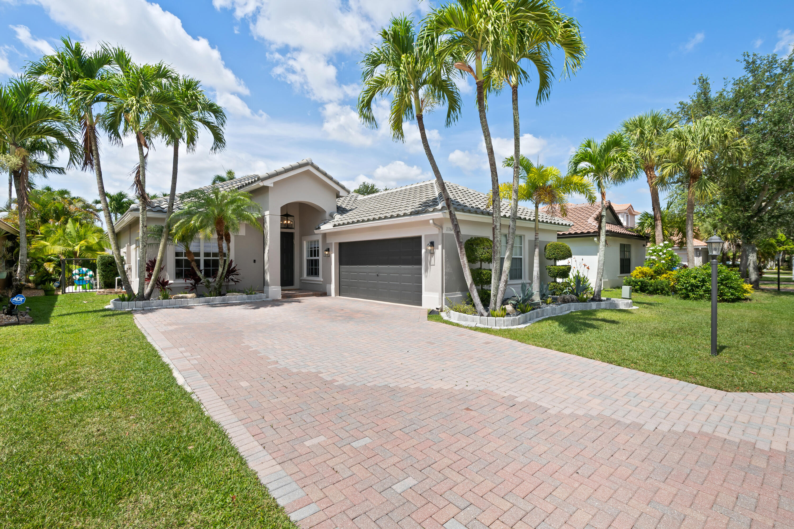 Introducing a refined expression of waterfront living in Parkland Isles- this impeccably renovated 3-bedroom, 2-bathroom single-story residence blends modern sophistication with effortless comfort.  Privately positioned on a quiet cul-de-sac street, the home opens to a resort-caliber outdoor retreat where a stunning saltwater pool and spa sit alongside a tranquil water backdrop. Framed by lush, manicured hedges and curated landscaping, the setting offers a rare sense of serenity and perfected privacy- an ideal backdrop for both intimate relaxation and upscale entertaining.  Inside, a light-filled open-concept design showcases clean lines, elevated finishes, and seamless flow throughout. The designer kitchen serves as the heart of the home, featuring premium Bosch appliances, sleek  cabinetry, and a thoughtfully curated aesthetic that balances beauty and functionality.  Every detail has been carefully considered to deliver a move-in ready experience with high-end upgrades, including a new roof (2023), new A/C (2023), and a fully reimagined outdoor space with marble pavers, updated pool finishes, and a heated saltwater system (2022). Additional enhancements include custom closet build-outs and a beautifully renovated guest bath.  A spacious 2-car garage and the ease of single-story living further elevate the home's livability.  This is a rare opportunity to own a turnkey waterfront residence where modern design, privacy, and location converge in one of Parkland's most desirable communities.