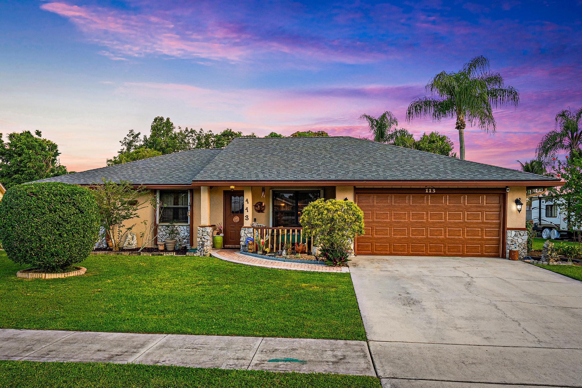 Welcome to 113 Cordoba Circle — where Florida living is at its finest. Nestled on an expansive 1/3-acre waterfront lot in the heart of Royal Palm Beach, this 3-bedroom, 2-bathroom home offers the perfect blend of privacy, nature, and everyday comfort. The split floorplan provides an ideal layout for both relaxing and entertaining, with the primary suite thoughtfully separated from the guest bedrooms for added privacy. Step outside and discover your own private tropical oasis. The lush grounds are adorned with mature fruit trees — including mango, avocado, and more — offering a bounty that only true Florida living can provide. The serene waterfront setting creates a peaceful backdrop you'll never tire of, whether you're enjoying your morning coffee or watching the sun set over the water. Ad ditional highlights include a newer roof (2025), spacious 2-car garage and generous lot size that offers room to spread out, garden, or simply soak in the natural surroundings that make this property truly one of a kind. Opportunities like this — a waterfront home with acreage, mature tropical landscaping, and a prime Royal Palm Beach location — don't come along often. Schedule your private showing today.