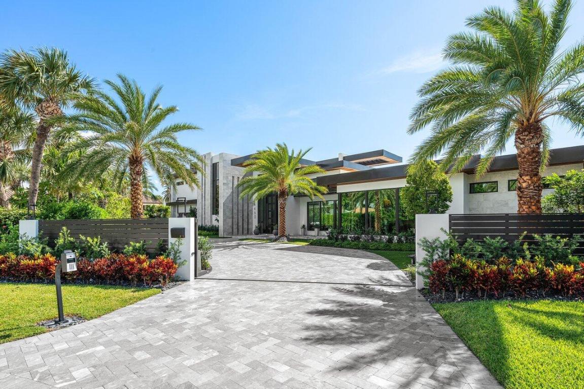 A Masterpiece of Modern Waterfront Living. Introducing a newly constructed, gated contemporary estate that redefines luxury on the Intracoastal Waterway, perfectly positioned on an expansive 161± feet of prime no-wake frontage directly across from the prestigious estates of Hillsboro Mile. Designed as a one-of-a-kind architectural statement, this glass-encased residence offers uninterrupted front-row views from nearly every major room, creating a seamless connection between interior elegance and the surrounding waterfront beauty. An awe-inspiring arrival begins with a cascading water wall entry that sets the tone for the exceptional design that follows. Inside, ultra-refined finishes abound—from a bespoke chef's kitchen with professional-grade appliances to imported tile, custom lighting, and a sophisticated private elevator. The entire north wing of the upper level is dedicated to an opulent Primary Suite sanctuary, featuring dual spa-inspired bathrooms, a private executive office, boutique-style wardrobe rooms, and an expansive sky deck offering panoramic views of the Intracoastal a true personal retreat. Designed for both grand entertaining and relaxed resort living, the outdoor space features a sleek pool and spa, entertainment-ready lanai, and meticulously landscaped surroundings. Boating enthusiasts will appreciate the rare state-of-the-art, industrial-grade boat lift, engineered to accommodate significant watercraft, along with deepwater dockage.