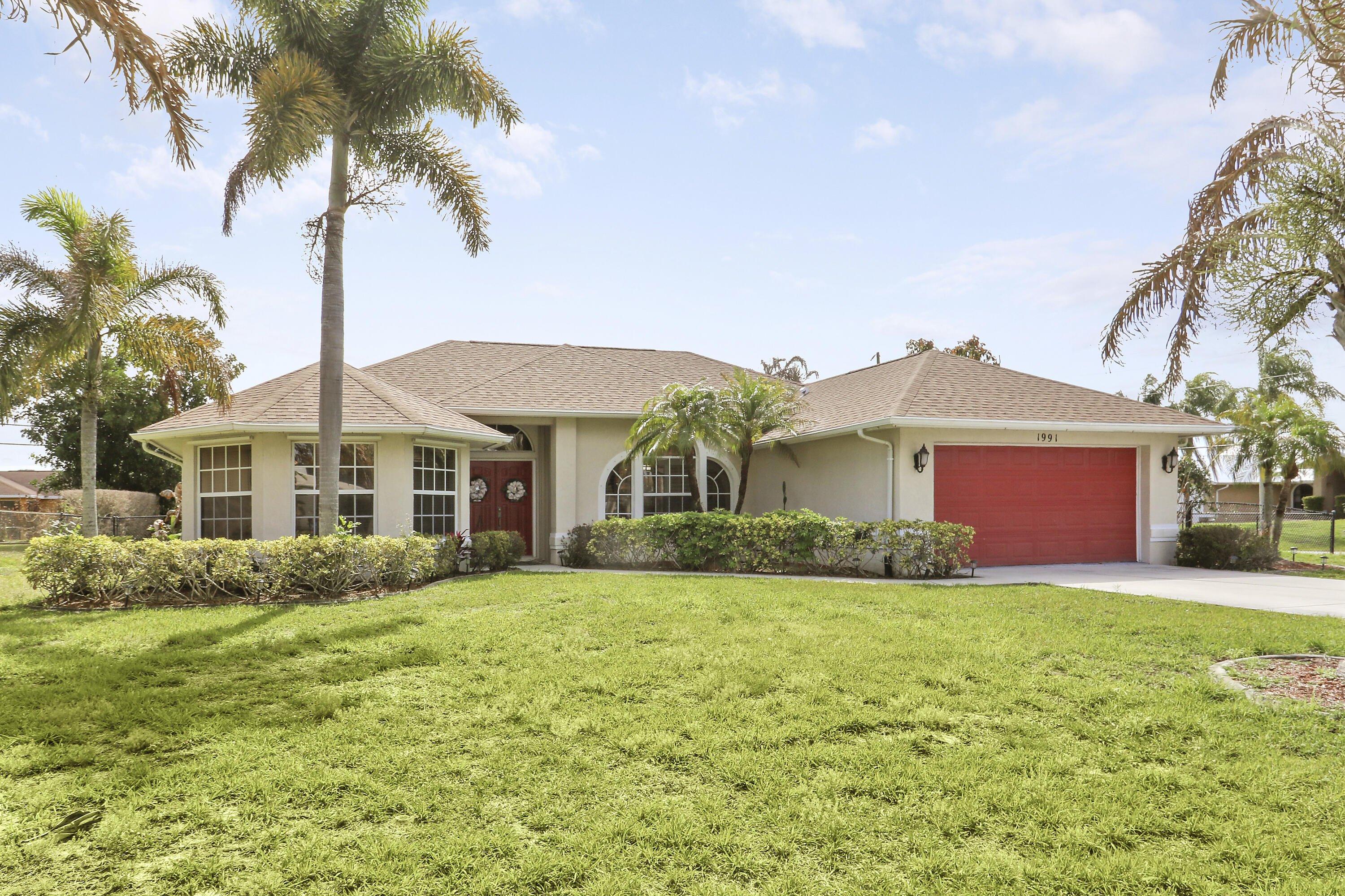 Spacious CBS 3 bedroom 2 bath plus large private family room/den pool home that sits on a 1/3 acre fenced corner lot in the heart of Port St Lucie. Relax on the 25 x 10 covered screened porch and take a swim year-round in the solar-heated pool. The upgraded kitchen includes space-saving wood cabinets, granite countertops, stainless steel appliances and a pass through window to the outside enteriaining/pool area. Additional features and upgrades include a new roof in 2020, accordian hurricane shutters which cover almost every window and door, vaulted ceilings, plantation shutters, a sprinkler system, a hot water heater (2022), pull down attic stairs which offer additional storage, and a child safety pool fence.   Additional interior features include both a formal living room and a spacious 20 x 14 family room/den with bay windows and double french door entry for added privacy.  Choose to serve your meals in the formal dining room, the breakfast bar off the kitchen or in the covered screened porch/pool area. Master bedroom has two walk-in closets. Master bath has separate tub, separate shower, and dual sinks. The living area has been updated with laminate wood flooring (the higher-end glue-together style). The exterior is equipped with accordion shutters on all windows except the bay window, dining room and den (that have regular aluminum shutters). Also an accordion shutter that goes across the entire back patio. Excellent curb appeal.
