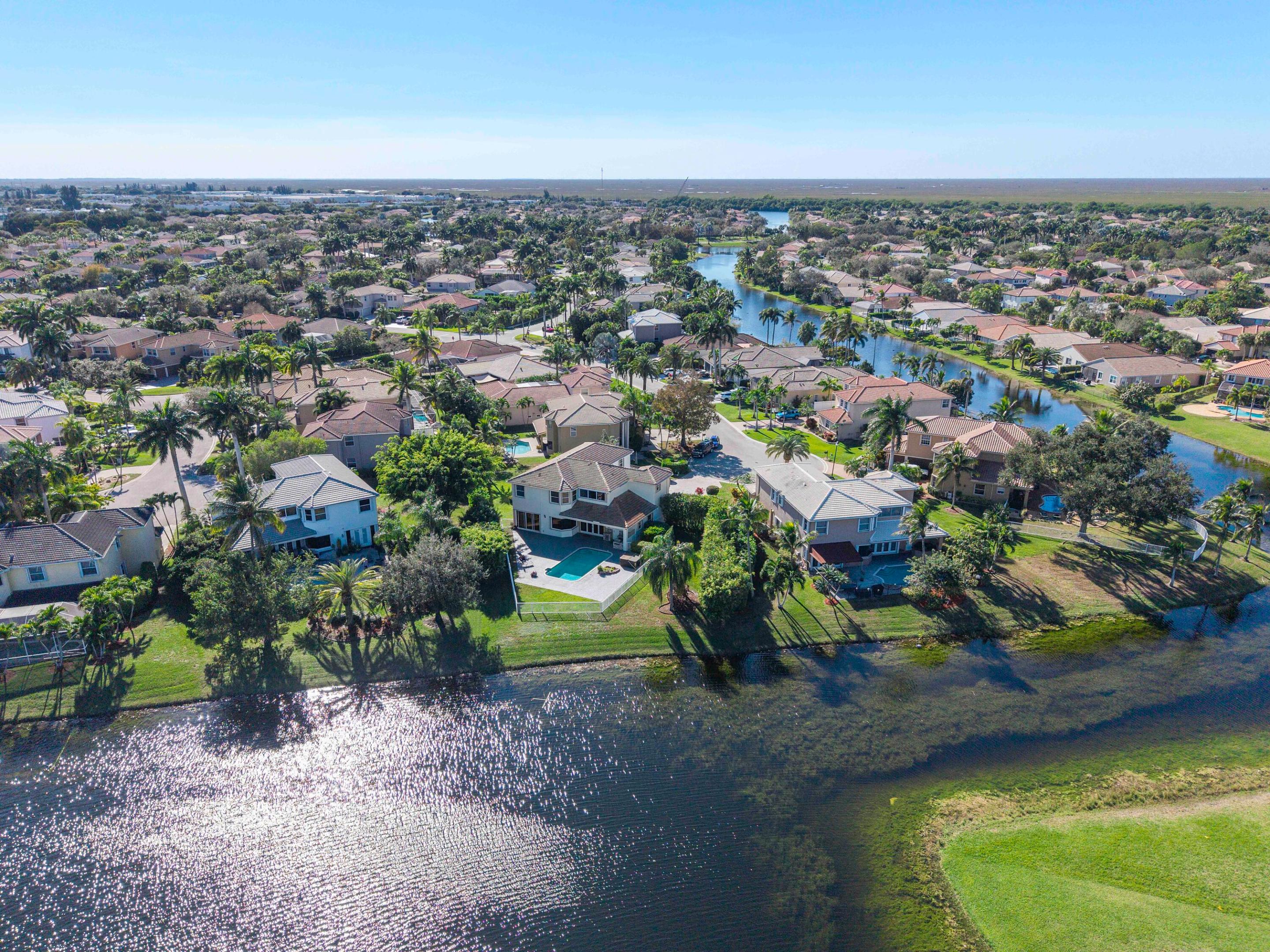 Brand New 24x48 Luxury Tile Flooring! Updated Modern Kitchen, Primary AND Guest Bathrooms! Move-in ready! Resort lifestyle: This colossal 7-BR waterfront estate is the largest in the community, set on a rare .38-acre cul-de-sac lot. Enjoy total privacy with panoramic lake views and total luxury with soaring 20' ceilings. The massive primary suite offers a private sitting area and spa-like bath. Outside, an entertainer's paradise awaits featuring a 27' covered lanai, outdoor kitchen, & heated pool. Serene water views and lush tropical landscaping surround you. Side-entry 3-car garage, PLUS parking for 8. First floor 20x20 wing functions as an office / 7th bedroom or REC room. Premier guard-gated community. Accordion Shutters throughout! LOW HOA dues.