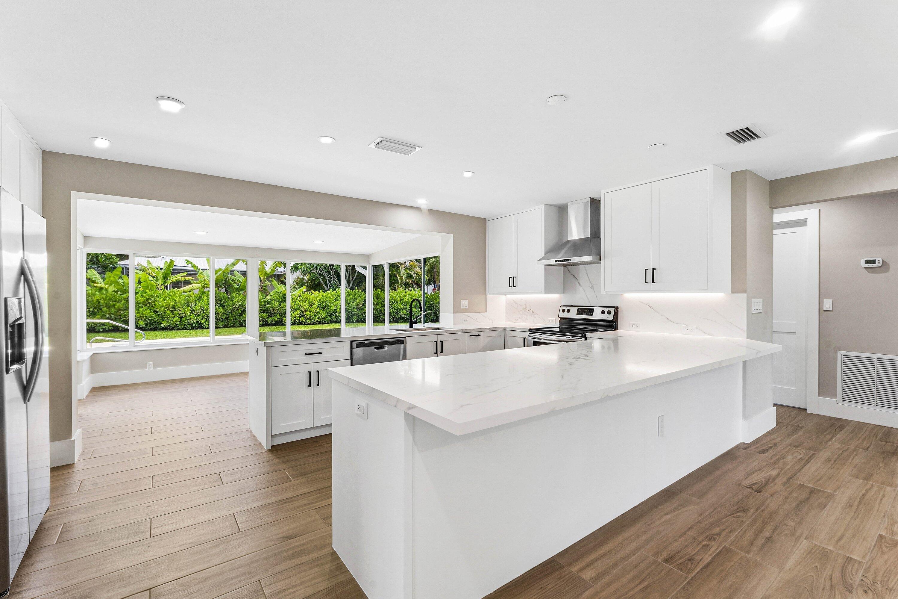Village of North Palm Beach. 3/2 pool home. Completely renovated coastal home.   Offered furnished or unfurnished annual lease.  This thoughtfully redesigned open floor plan, features a stunning chef's kitchen with quartz countertops, custom cabinetry, premium appliances, and an expansive island overlooking the spacious living areas and Florida sunroom.  Large impact windows and doors fill the home with natural light, while providing peace of mind and energy efficiency.  Every detail has been upgraded, including a new metal roof, new air conditioning system, new water heater, designer wood-look porcelain tile flooring throughout, beautifully renovated bathrooms, custom built-in cabinetry. Split bedroom floor-plan. Primary Suite features walk-in custom closet.  Home includes a dedicated laundry/utility room with full-size washer and dryer. Along with extra storage. Step outside, to your private backyard oasis featuring a large swimming pool and oversized corner lot. Perfect for entertaining or relaxing in the Florida sunshine.  Located east of US-1 in one of Palm Beach County's most sought after, coastal communities. Residents enjoy a charming neighborhood known for boating, waterfront parks, golf, tennis, pickleball, and convenient access to the Intracoastal Waterway. Just minutes from Palm Beach Gardens, Downtown West Palm Beach, Palm Beach Island, shopping, dining, beautiful beaches, and Palm Beach International Airport.  Available as an annual, unfurnished lease $5,600 monthly. Or annual, furnished lease $6,500 monthly.  Furnished photos have been Virtually Staged.