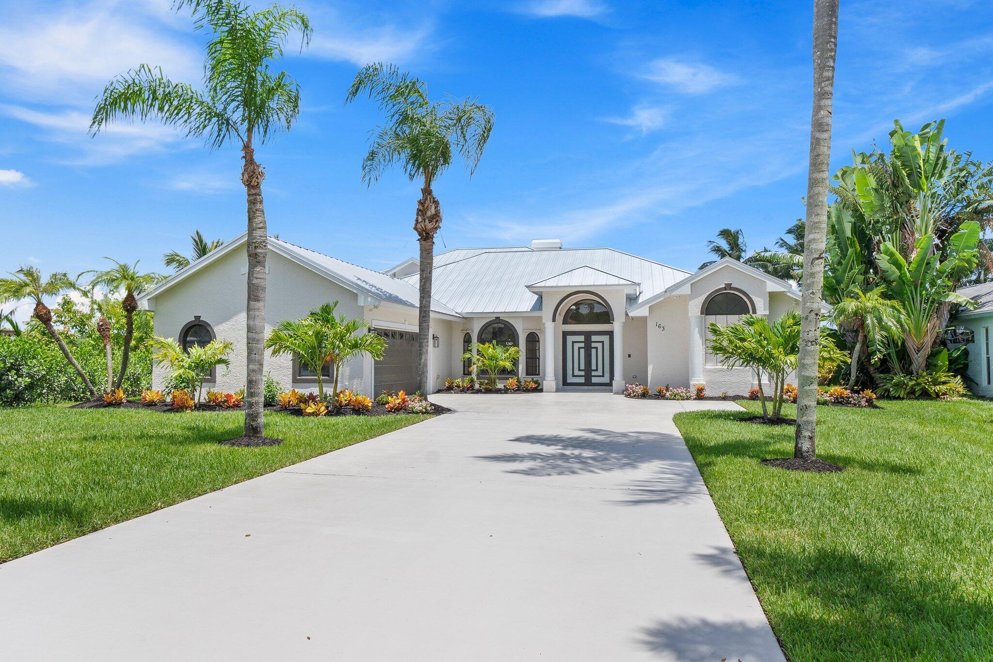 Stunning REMODELED home is a coastal contemporary architecture blend of highly desirable finishes & details! This exceptional waterfront home shows like a Model! Details include New Metal Roof, 1/2 acre lot with great curb appeal & exceptional setting! Impressive 5 Bedrooms, 2 Baths, 2.5 Car Garage & fabulous outside area boasting screen enclosed resurfaced pool with spa, travertine decking, party deck & private dock overlooking breathtaking water views. Just a short boat ride to Ocean Access. Gated community with only 34 private homes is a hidden secret & real gem! Beautiful double door entrance, luxury open concept, volume ceilings & 48 x 24 gorgeous porcelain tile sets off the tone of this home. Fabulous Gourmet kitchen, featuring 16x5 quartz island & backsplash.  This Chef's kitchen includes Electric Cooktop, custom cabinetry, pop up smartphone charges in island, separate wine bar counter space with quartz counter top and wine cooler, wall oven & recessed LED Lights perfect for entertaining & the heart of the home. Dramatic Formal living Room, Dining Room, family room with an elegant Coral fireplace & flex room perfect for a bar, pool table or just gracious living whether entertaining family & friends with sliding glass door, natural lighting & stunning Views. This home is for the most discriminating buyer!  Grand Master Suite offers split floor plan & the tranquil timeless SPA LIKE master bathroom boasts raised Vanity Cabinets, dual sinks, waterfall bathroom faucets, 14 foot Luxury Sports Shower & stand alone soaking tub. Upstairs you will find 5th bedroom or private space with a walk out balcony overlooking the beautiful waterway canal. When you think about Florida Living you will love the outdoor space! The tropical oasis will give you privacy, tranquility & Joy. Bring you boat & slow down to the pace you have been looking for & the lifestyle you want! Roof 2023, 2 New A/C units & Garage is 2 plus golf cart garage space or storage space with fabulous epoxy flooring.