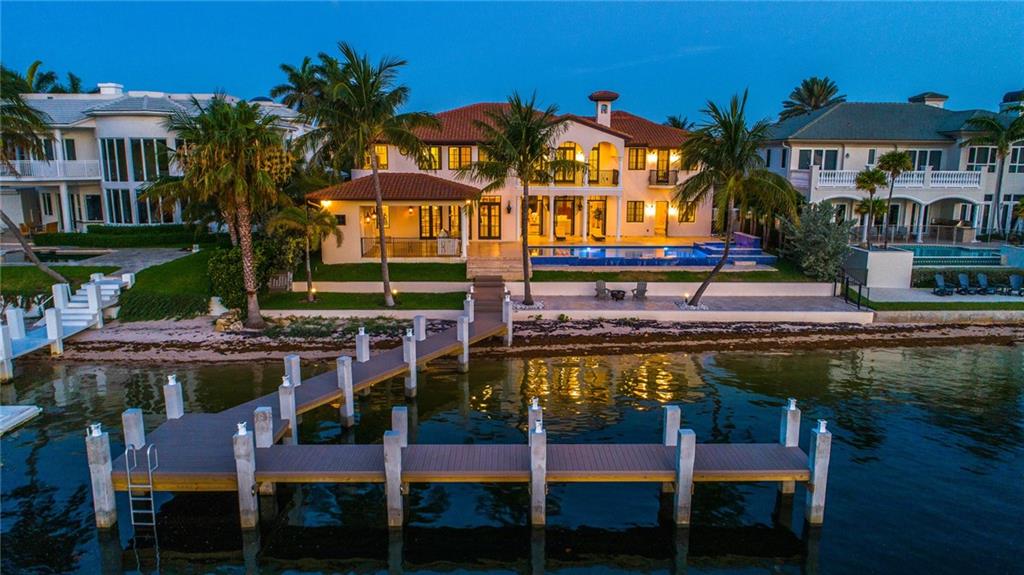 New Lighthouse Point Intracoastal Estate sited on 100 +/- feet of waterfrontage w/sandy beach & yacht dockage minutes to the Hillsboro Inlet. A grand foyer entrance w/ graceful rotunda staircase opens this light-filled estate with free flowing rooms & views to the ICWW. Gourmet island kitchen with wraparound breakfast bar and morning room w/banquet seating. Great Room with fireplace, coffered ceiling & professional bar. Resort style pool with beach entrance.Entertainment pavilion w/summer kitchen & cabana