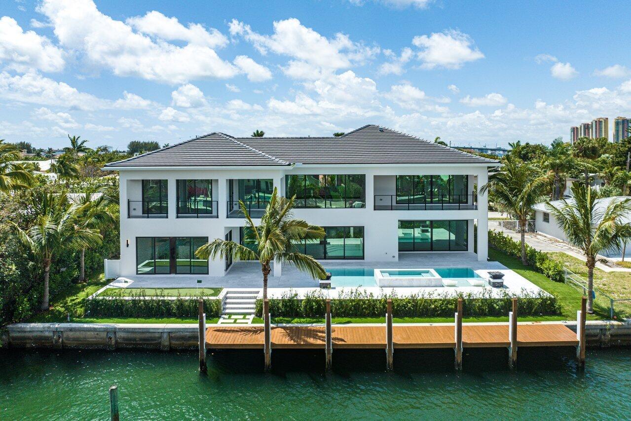 Step into the realm of waterfront opulence - a newly crafted masterpiece featuring four spacious bedrooms, including two luxurious master suites - one on each floor for seamless guest hosting. The open-concept living area, adorned with modern finishes and meticulous design, includes a top-tier kitchen and an expansive island. Outdoors, discover a private saltwater pool and Jacuzzi, perfect for relaxation and hosting summer gatherings. With 100 feet of waterfront access and situated just four homes away from the Intracoastal, complete with a large turn basin, docking your boat in your backyard creates an effortless gateway to oceanic ventures.