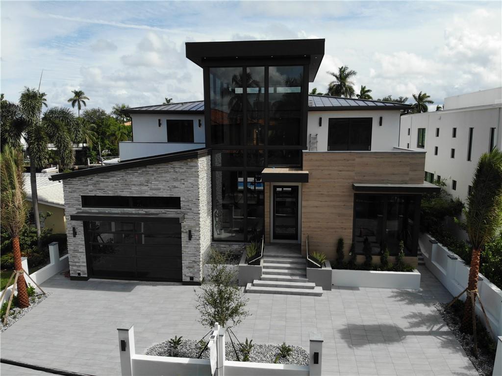 Completion date October 2020! This new construction masterpiece offers the perfect opportunity to live your luxury lifestyle in Las Olas Isles! A grand entryway with a 32 ft' ceiling, entrance waterfall lead the way to the open floor plan with a chef’s kitchen, dining and living area with a linear gas fireplace, game room with bar, 2 half baths, laundry room and owner’s suite. 2nd floor features 4 add'l ensuite bedrooms with balconies and a second laundry room. The backyard features a spa that cascades into the pool, fire bowls, outdoor kitchen and concrete dock. This smart home has high-end finishes and a full-house generator. THE NEW COCONUT ISLE BRIDGE & ROAD PROJECT TO BE COMPLETED BY DECEMBER. Lot next door can be purchased for combined water-frontage of 130 ft'.