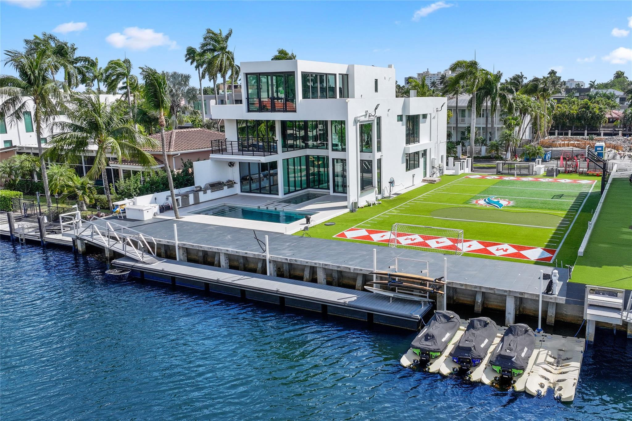 This modern estate on the Las Olas Isles offers 100’ of waterfront on a wide canal with ocean access & no fixed bridges. Spanning 2 lots, the property features a one-of-a-kind field for football, soccer, putting, etc. The home showcases floor-to-ceiling glass with stunning views & includes an elevator for easy access to all levels. The 3rd floor features a wet bar, enclosed gym, open terrace & spectacular views of downtown Fort Lauderdale. The open-concept layout includes a gourmet kitchen with an oversized island, perfect for entertaining & seamless indoor-outdoor living. Fully integrated with Control4 smart home technology, the home also features a resort-style pool, summer kitchen & dock. Plenty of parking with a 2-car garage & 2 driveways. Prime location near shops, dining & beach.