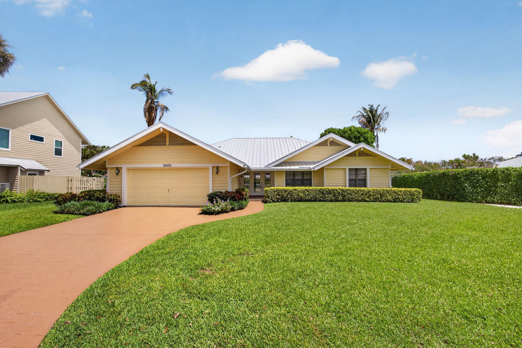 Welcome to Jupiter Narrows, a sought-after Hobe Sound community known for its picturesque streets and atmosphere. This well-maintained 3-bedroom, 2-bath residence features a new metal roof, freshly painted exterior, and beautiful tile and hardwood flooring throughout. The spacious living area opens seamlessly to a generous deck overlooking a lush, manicured backyard, offering the perfect backdrop for entertaining or relaxing outdoors. Ideally located just minutes from beaches, boating, dining, and shopping, this home presents an exceptional opportunity to enjoy the best of coastal Florida living