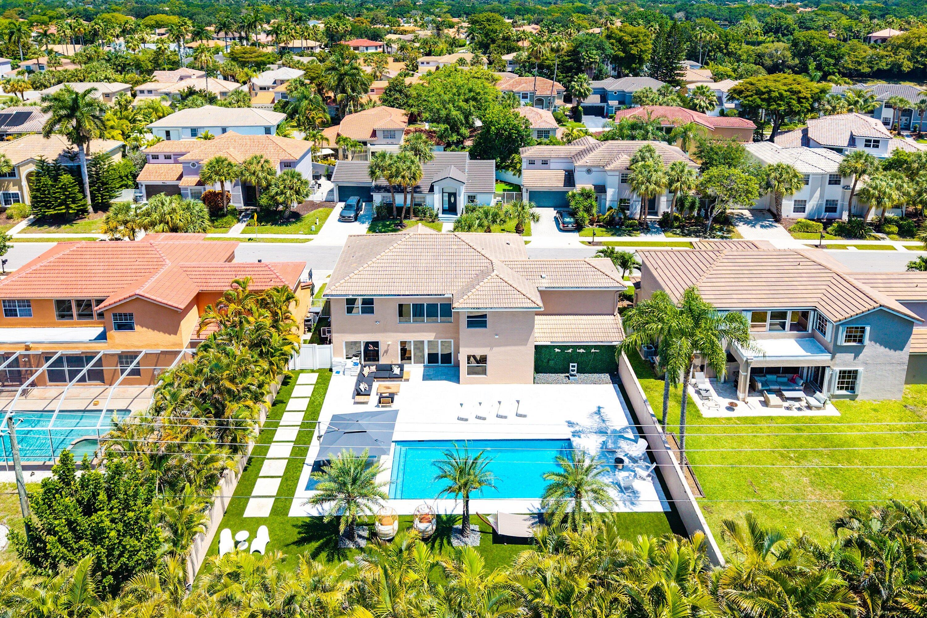Arguably one of the best backyards currently available in Mission Bay. Situated on one of the community's largest and most private golf course lots, this fully upgraded 5BR/4BA residence has been transformed into a true resort-style retreat. The outdoor space is the showpiece — featuring a brand-new custom pool, marble paver deck, oversized turf lawn, and built-in putting green, all backing directly to Boca Woods Country Club with no rear neighbors. Inside, soaring ceilings and natural light complement the home's modern design and open layout. Complete impact windows and doors throughout. Located in gated Regatta at Mission Bay with resort-style amenities, plus cable & internet included in HOA. Originally designed as a 4-bedroom home, the loft has since been professionally enclosed to create a true fifth bedroom, adding both functionality and flexibility. The renovated kitchen features sleek cabinetry, stone countertops, stainless steel appliances, and seamless flow into the main living areas. All bathrooms have been tastefully updated. Regatta at Mission Bay is ideally positioned within walking distance to both the clubhouse and the Mission Bay Community Park. Residents enjoy access to a clubhouse, fitness center, tennis, pickleball, community pool, playgrounds, and more. Rare opportunity to own a move-in ready 5-bedroom pool home with exceptional privacy, major upgrades, and one of the most impressive outdoor living experiences in West Boca.