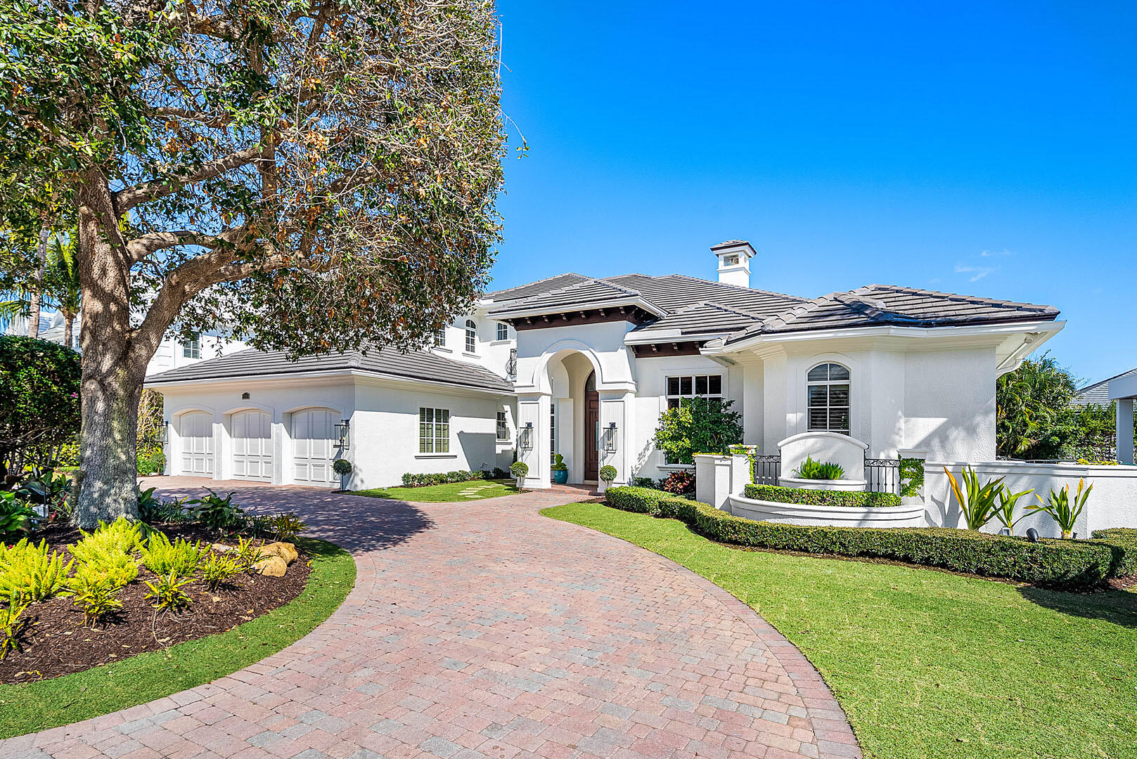 Situated within the prestigious Royal Palm Yacht & Country Club, this refined two-story residence offers over 5,000 square feet of thoughtfully curated living across five bedrooms, designed for both grand entertaining and everyday ease. A spacious, open floor plan unfolds with warmth and intention, recently refreshed with rich wood floors, custom trim, and carefully selected lighting that brings a timeless, tailored feel to every room. The heart of the home is a chef's kitchen built to impress, featuring an expansive center island, premium appliances, a walk-in pantry, and a dedicated beverage center with wine refrigeration. Living and dining spaces flow seamlessly to the covered patio, where retractable screens, dining space, and lounge seating overlook a private backyard retreat complete with a custom heated pool and raised spa. A private study with custom wood built-ins provides a quiet workspace, while the first-floor primary suite serves as a true sanctuary, offering a spa-inspired bath and generous his-and-her walk-in closets. Upstairs accommodations are well-proportioned and private, ideal for family and guests alike. Additional features include natural gas, brand-new A/C systems, an elevator, a first-floor guest suite, and full impact glass and doors ensuring comfort, efficiency, and peace of mind. Positioned in one of Boca Raton's most sought-after communities, this home delivers a rare combination of scale, craftsmanship, and lifestyle-driven design.