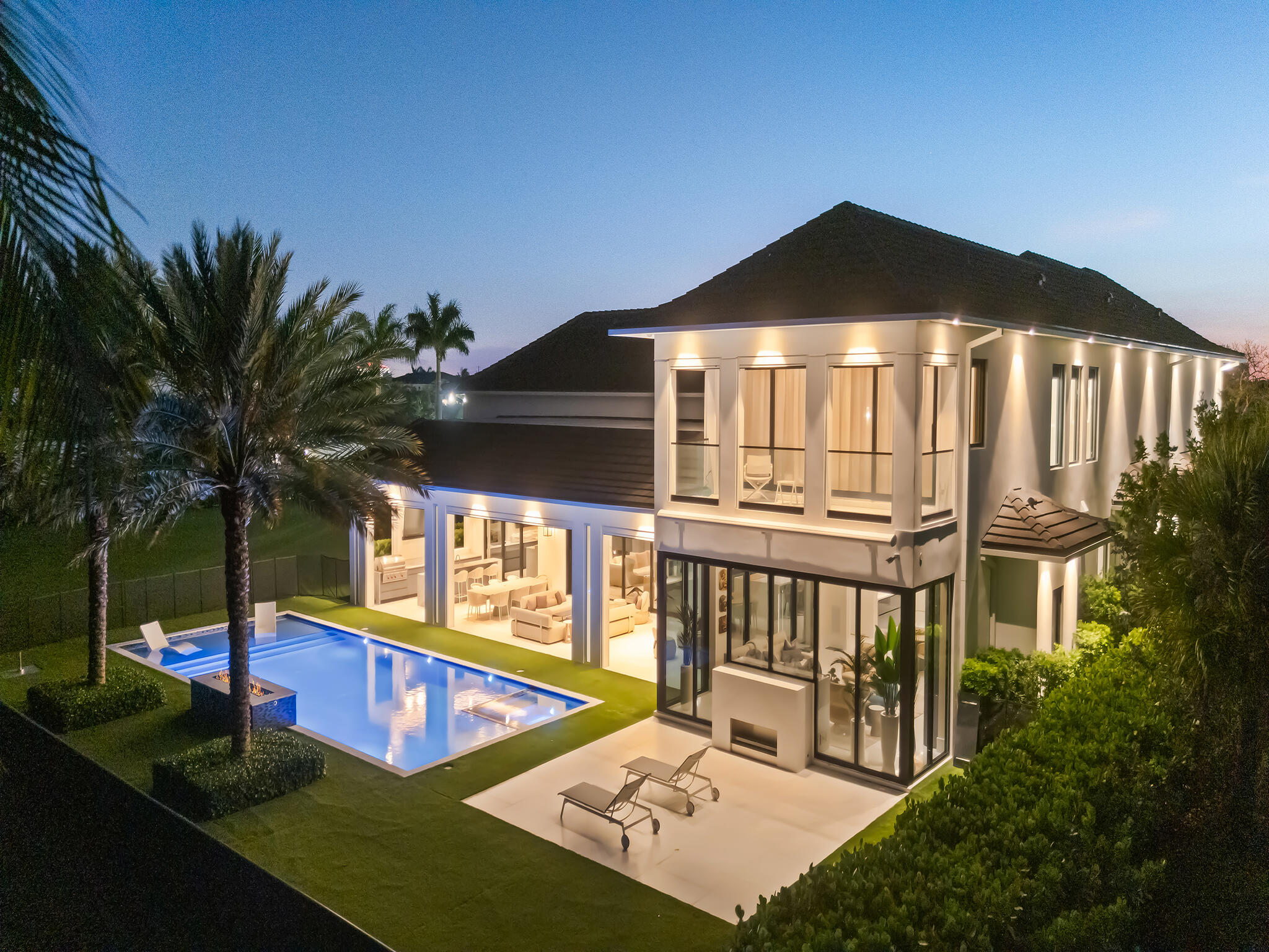 Experience unparalleled luxury at this exclusive residence nestled within the prestigious The Enclave at Coral Ridge Country Club in Fort Lauderdale. This magnificent double lot estate, spanning over 0.75 acres, offers exceptional privacy and ample space for entertaining and relaxation, complemented by breathtaking views of the golf course and serene lake. As one of only 36 residences, this opulent home boasts a grand room with soaring 20-foot ceilings, a custom bar, a spacious wine room, and a formal dining area. The expansive gourmet kitchen is equipped with high-end Miele, Sub-Zero, and Wolf appliances, Italkraft cabinetry, an expansive island countertop, conveniently located adjacent to an entertainment room featuring a fireplace and stunning views. The primary suite exudes elegance with Italian wall paper, a recently completed dressing room, dual showers, a tub, dual vanities, and a screened private balcony. The fifth bedroom currently serves as an exercise room. The outdoor covered lounge area provides an ideal entertainment space, complete with a summer kitchen, heated pool, fire pit, water features, and spa. Additionally, there is a covered patio and an outdoor fireplace. Control 4 automation, a climate-controlled four-car garage, a glass elevator, and a full-size house generator are among the numerous comprehensive features that this exceptional estate offers. This unique and exclusive residence is a true gem, waiting to be cherished.