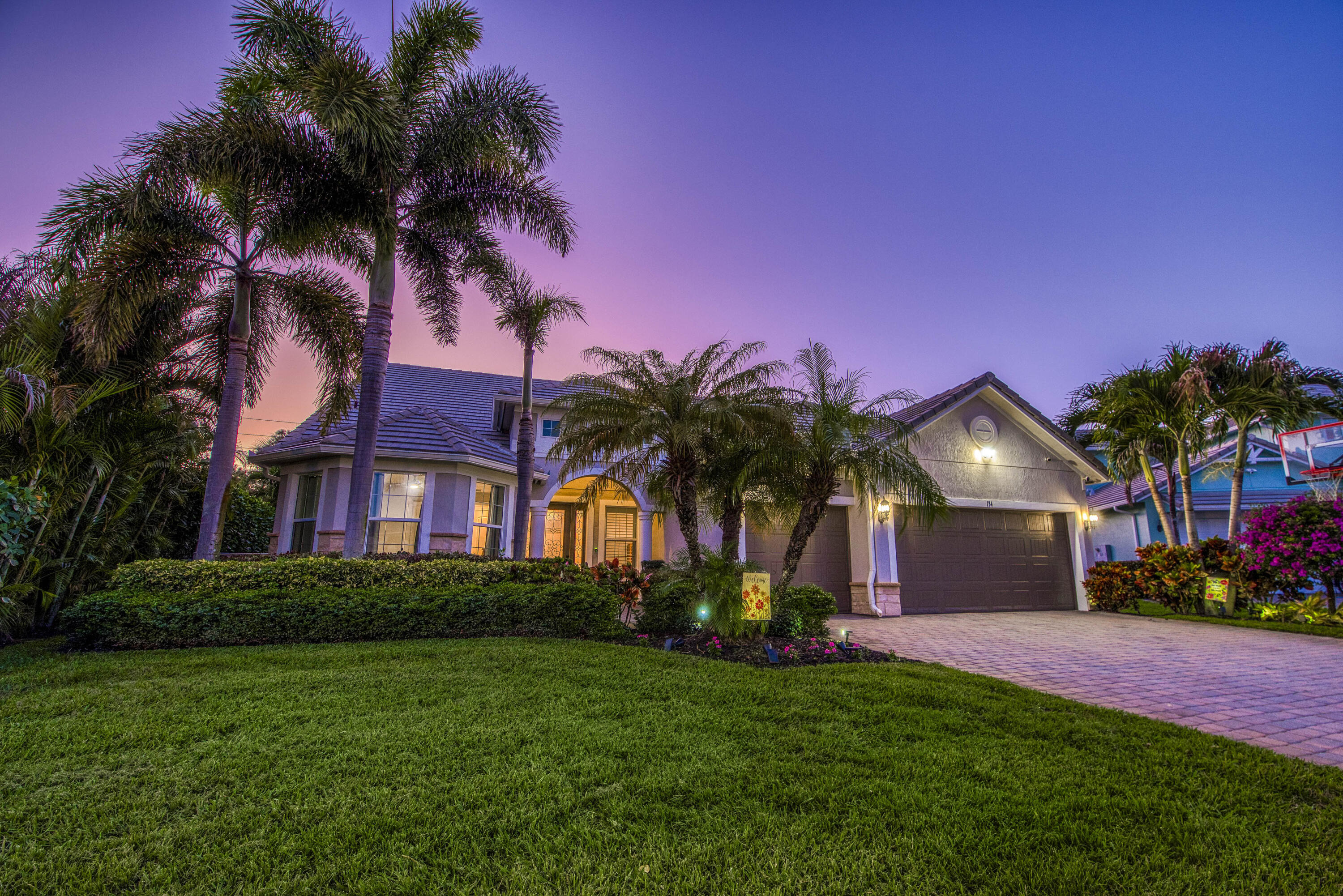 This unique and highly sought-after Pinnacle + Loft floor plan is now available in the sought-after 31-home boutique community of Shores Pointe, nestled in the heart of Jupiter. This spacious two-story, split-bedroom residence offers 4 bedrooms, 4 baths, a den/flex room, a large upstairs loft living area, and an extended 3-car garage. Built in 2017 with exceptional attention to detail, this beautifully upgraded home showcases quality and design from the moment you enter through the custom impact glass front door. Designer finishes include porcelain wood-look tile flooring, solid core doors, stylish lighting fixtures, crown molding, plantation shutters, tray ceilings, and refined touches throughout. Constructed with CBS and designed for comfort and peace of mind, the home features impact glass windows, natural gas, a 24 kW whole-house generator, and newer A/C units (2024 & 2023). The open-concept great room serves as the heart of the home, highlighted by volume ceilings and serene views of the palm tree-lined backyard. The gourmet kitchen is a true showpiece, featuring a large quartz center island with pendant lighting, white shaker cabinetry, tile backsplash, a 5-burner gas range, a spacious walk-in pantry with custom solid shelving, and a dedicated coffee/wine bar—ideal for both everyday living and entertaining. The expansive primary suite offers a tranquil retreat with a tray ceiling, sitting area, and a massive custom walk-in closet. The spa-inspired primary bath includes porcelain tile flooring, quartz countertops, elegant vanity lighting and a frameless glass walk-in shower. The versatile downstairs den/flex room can easily serve as an office, media room, home gym, or convertible 5th bedroom. Two guest bedrooms are also located on the main level. Upstairs, you'll find an impressive guest suite with extensive built-in closet storage, along with a generously sized loft providing additional living space for relaxation or entertainment. Step outside through impact glass sliders to your private backyard oasis. Enjoy beautiful sunset views from the screen-enclosed covered patio, with an oversized lot offering ample room for a future pool. Mature palm trees line the perimeter, providing exceptional privacy with no rear neighbors. Additional features include smart home technology such as a doorbell camera and Vitex security system. Shores Pointe is zoned for A-rated schools and offers a private playground/park along with walking path access to the Southwest Fork of the Loxahatchee River - perfect for launching a paddleboard or kayak. Ideally located near I-95, the Florida Turnpike, beaches, shopping, dining, parks, and nature preserves - this is Florida living at its finest!