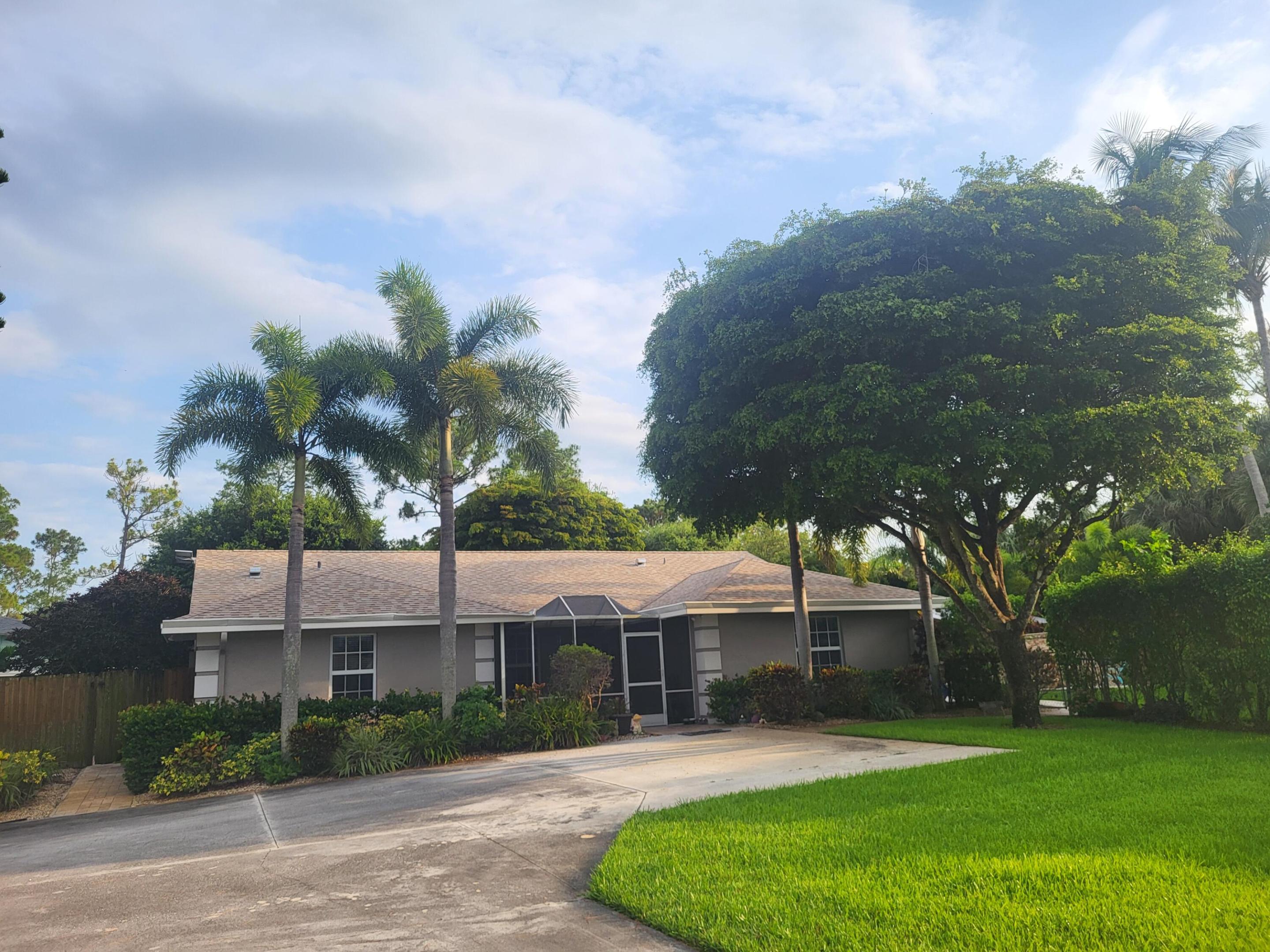 This fantastic pool home can now be yours. This CBS 3/2.5 plus bonus multi-purpose 4th sits on a mostly fenced and landscaped acre+ in one of the most desirable no HOA communities in PB County.  Outdoor amenities galore including a custom built pool with water & lighting features plus a walk around spa, expansive marble paver pool deck, an outdoor kitchen/BBQ in a 14x22 Tiki Bar, a covered patio along the rear of the home and multiple storage sheds/workshop areas. This home also has a 9 zone irrigation system on well, and a full home generator. Multiple entry gates, a large (unfenced) circular driveway and a dedicated gravel RV pad. Home is completely tiled, new roof June 2023, all impact windows and doors 2004, AC March 2023, Frigidaire kitchen SS appliances 2020 and new HWH July 2025.