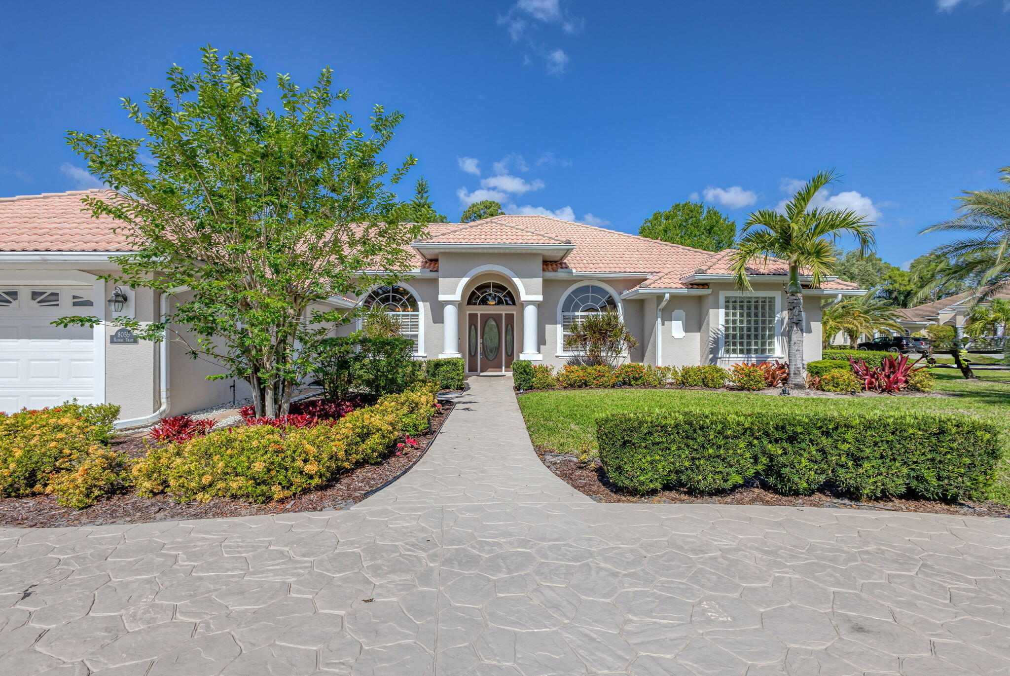 Welcome to 8055 Kiawah Trace, a beautifully maintained home nestled in the desirable PGA Village community of Port St. Lucie. This inviting residence offers a perfect blend of comfort, style, and Florida charm. From the moment you arrive, you'll be captivated by the manicured landscaping and elegant curb appeal. Step inside to find a spacious open-concept floor plan, ideal for both relaxing and entertaining. The living area features abundant natural light and seamless flow into the dining and kitchen spaces. The kitchen is a chef's delight, complete with modern appliances, ample cabinetry, and a breakfast bar for casual meals. Enjoy a peaceful retreat in the primary suite, which boasts a walk-in closet and a well-appointed en-suite bath. Additional bedrooms provide flexibility for   family, guests, or a home office. Outside, a stunning pool with new LED lights that add extra ambiance in the evening, with a private screened patio overlooks a lush backyard perfect for enjoying Florida's year-round sunshine. Located in a gated, golf course community, this home also includes access to resort-style amenities such as pools, tennis courts, fitness centers, and more. With close proximity to shopping, dining, and beaches, this home offers a truly exceptional lifestyle. HOA includes Internet and Cable. This home is snowbird / everybody turnkey sold with most of the furniture. This home is not to be missed.