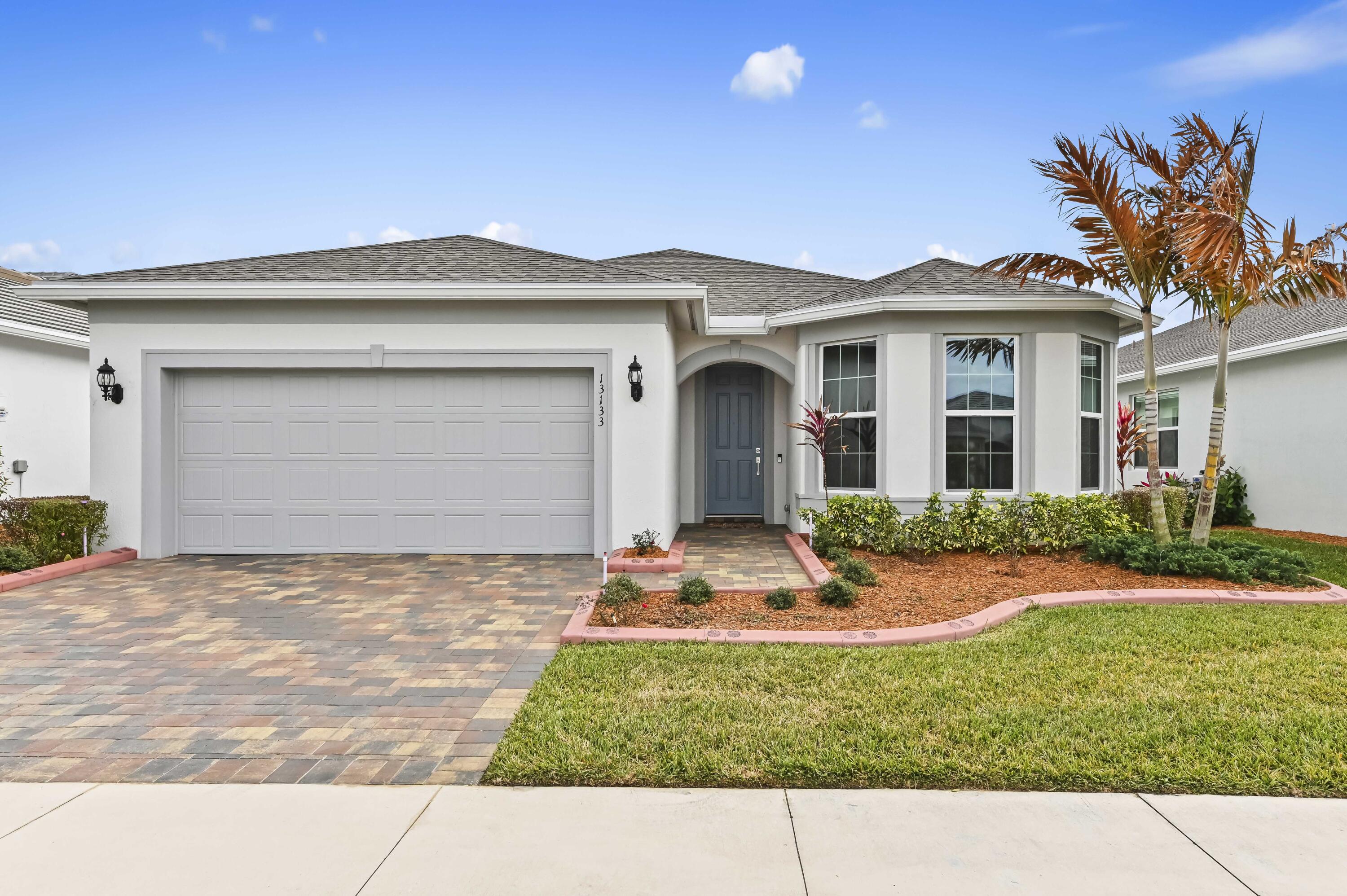 Welcome to 13133 SW Smalt Lane. Brick pavers on the driveway and sidewalk lead to this beautiful 2 bedroom 2 bathroom 2055 sq ft well kept home, located in the 55 plus gated community of Del Webb. This home features impact resistant windows and 8 foot doors, upgraded fans and light fixtures, Quartz counter tops in the kitchen and baths, plus the cabinets have pull out shelves and soft close drawers and doors. The appliances are upgraded including a gas stove, dryer, and water heater. All windows are tinted. There is 12" X 24" attractive and durable tile flooring throughout. Upgraded kitchen appliances compliment the large Quartz island. Some furniture could be included. An impressive laundry room includes upgraded washer and dryer and large storage room. The primary suite includes a tray ceiling and ensuite bath with dual sinks, walk-in shower, private toilet, and large walk-in closet. Bath #2 has a luxurious soaking tub and shower. The flex room can be used for visitors, office, or hobbies. Decorative concrete curbing enhances the front yard, while the fenced backyard includes curbing inside and outside the fence, creating a large flowerbed.  The 3-car tandem garage features a finished floor, wall cabinets, and a workbench that could be used for a workshop, storage, and more. HOA fees include all lawn maintenance and world-class amenities. Home is conveniently located near shopping and medical services.