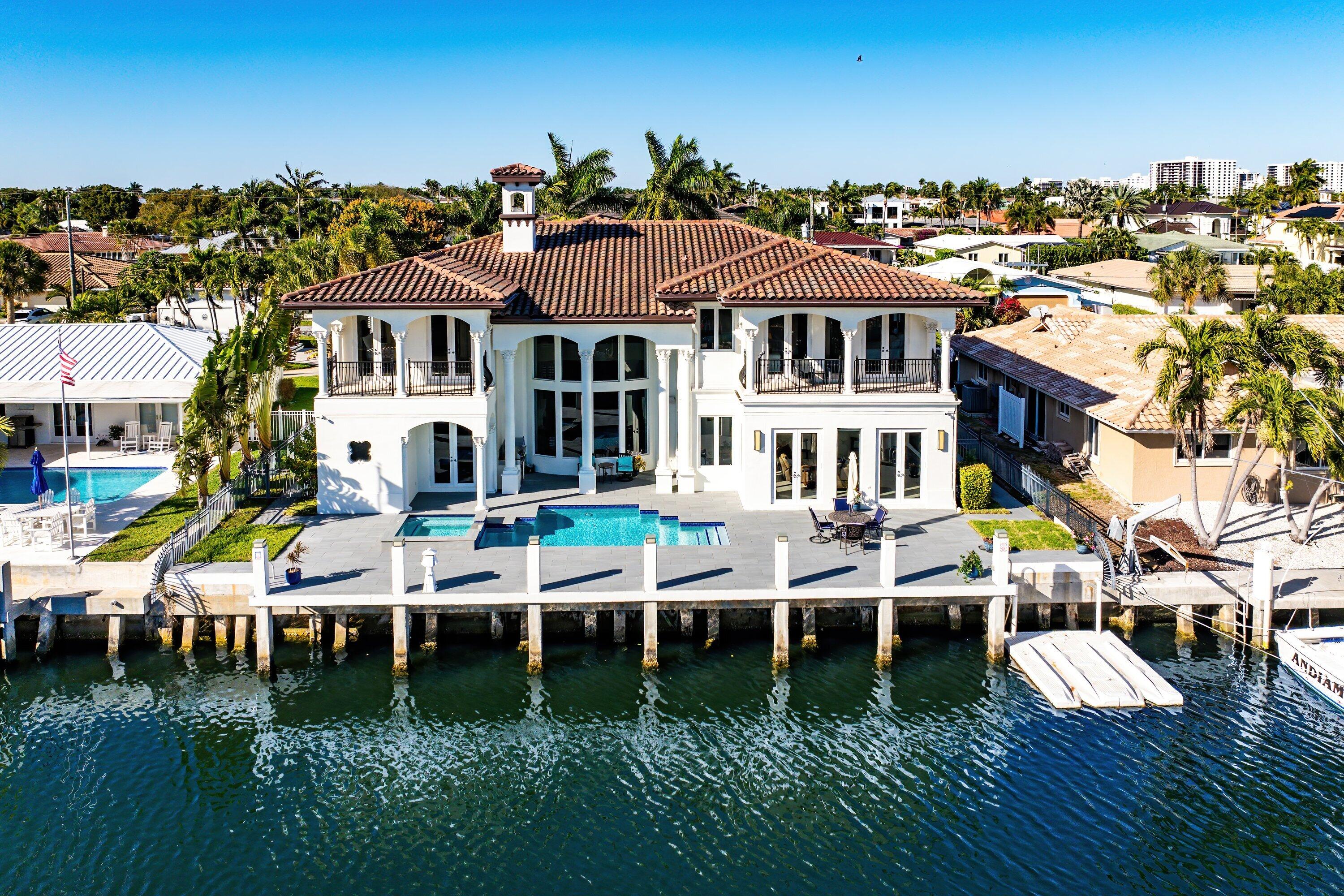 A Masterpiece of Gated Mediterranean Waterfront Living in Boca Raton

Commanding a premier position just off the Intracoastal with coveted southern exposure, this magnificent deepwater Mediterranean estate defines refined coastal luxury. Set within a private gated enclave and fronting a wide turning basin, the residence offers 85 feet of prime dockage, delivering an exceptional yachting lifestyle for discerning boaters.

This custom-built estate showcases five expansive bedroom suites, 4.5 baths, a stately library, and four walk-out balconies, all executed with uncompromising craftsmanship and timeless elegance. Marble floors flow throughout the main living areas and ascend the dramatic wrought-iron grand staircase, creating a seamless sense of grandeur. The grand living room makes a striking statement with a floor-to-ceiling stone, wood-burning fireplace and elegant bay windows framing serene water and pool views. Designed for sophisticated entertaining, the resort-style outdoor oasis features a spacious pool, spa, and fully equipped summer kitchen with custom gas grill--perfect for alfresco gatherings beneath the Florida sun.

At the heart of the home, the show-stopping chef's kitchen is a culinary masterpiece, appointed with top-tier appliances including a Sub-Zero refrigerator, Thermador gas cooktop, Bosch dishwasher, and double ovens, anchored by an oversized granite island with prep sink--equal parts functional and stunning.

The luxurious primary suite is a private sanctuary, offering a generous bedroom, private balcony, morning bar, and a newly reimagined spa-inspired bath designed for pure indulgence. Additional living spaces include an elegant library and multiple balconies, ideal for savoring gentle coastal breezes and golden sunsets.

Impact-resistant windows and French doors provide security and peace of mind, while a 2017 roof enhances long-term value and durability. With exceptional southern exposure, premier water frontage, yacht-ready dockage, and an elite Boca Raton location, this extraordinary estate represents the pinnacle of waterfront living.