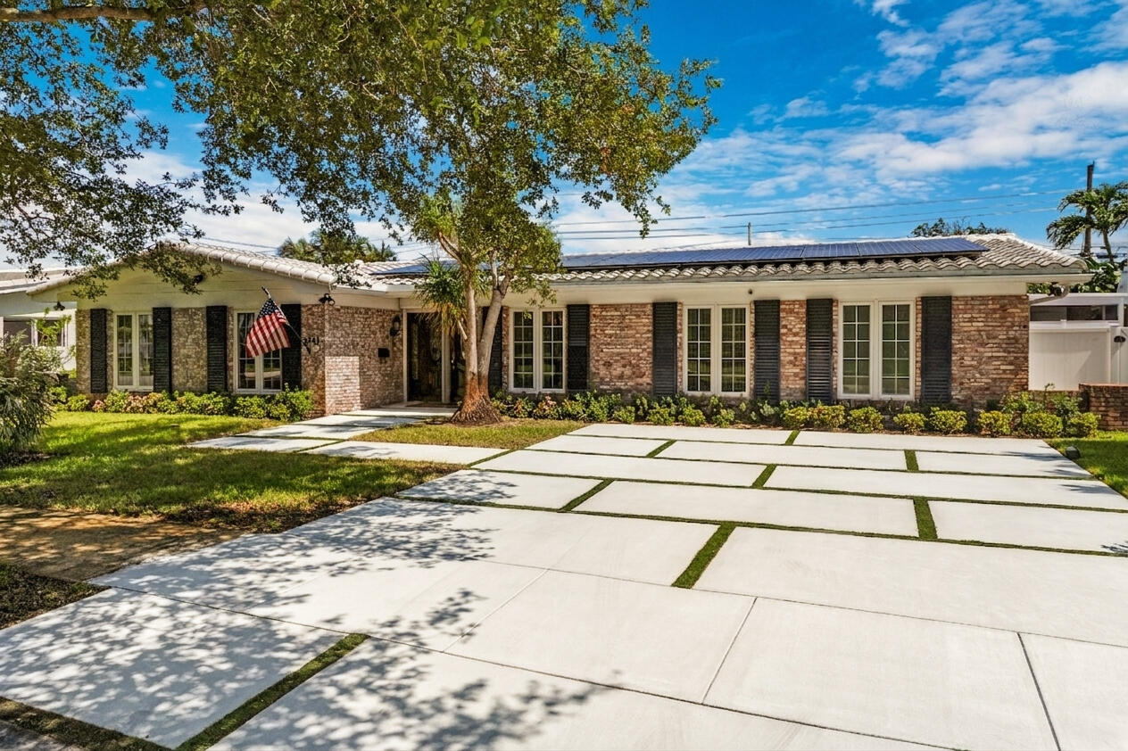 Step inside this rarely available 5 bedroom, 4 bathroom pool home in the highly sought-after Imperial Point neighborhood, offering a spacious split floor plan, fully paid solar power system, full impact windows and sliding doors, and exceptional indoor-outdoor living.  Set beneath mature oak trees on a beautifully landscaped property, this home immediately stands out with its classic brick exterior, functional colonial shutters, decorative driveway with custom turf detailing, and timeless curb appeal. Inside, a formal foyer welcomes you into an expansive layout featuring a formal living room, separate family room, multiple dining areas, and thoughtfully designed spaces that provide flexibility for families of all sizes. The layout offers privacy and functionality with a spacious primary suite, two additional ensuite bedrooms with private baths, including a convenient cabana bathroom with direct pool access. The generous kitchen includes a dedicated pantry and a large pass-through window that seamlessly connects indoor and outdoor entertaining spaces. The family room features a custom built-in entertainment center, while built-in shelving and storage throughout the home enhance everyday organization and functionality. Step outside to a private backyard oasis designed for year-round South Florida living. The screened outdoor living area features a wood-burning fireplace with plenty of room for entertaining. Next to the pool you'll find a fully equipped outdoor kitchen with a gas grill, Big Green Egg ceramic cooker, and refrigerator, creating the perfect setting for gatherings and outdoor dining. The private pool is surrounded by lush landscaping, mature tropical plantings, and vibrant bougainvillea. The additional side-yard spaces provides a convenient area for storage, gardening, or keeping outdoor equipment organized. Major upgrades include a 13.5 kW fully paid-off solar power system capable of powering the entire home, full impact windows and doors, roll-down shutters protecting the Brazilian mahogany front door, portable generator hookup, security cameras, and a closed-circuit security system. An agricultural well services the irrigation and sprinkler system, helping reduce water costs while maintaining the beautifully landscaped grounds. Imperial Point is a walkable and welcoming Fort Lauderdale neighborhood famous for its street lights and sidewalks. Quiet streets, mature trees, and a strong sense of pride make it easy to feel at home. Primarily made up of single-family homes, many with updated interiors and generous lot sizes, its walkable layout encourages everything from morning strolls to evening dog walks. Just half a mile to the local Publix Supermarket and Holy Cross Hospital, just minutes away. Quick access to 2 beaches. Just 2 miles to Lauderdale By The Sea Beach & 2 miles to the New Pompano Beach, fishing pier, new restaurants, and luxury waterfront dining. For travelers and commuters, you'll have easy access to US-1 and I-95. FLL Int'l Airport is 20 minutes away, Miami Int'l Airport is 45 minutes away, and Palm Beach International Airport is 40 minutes away.
