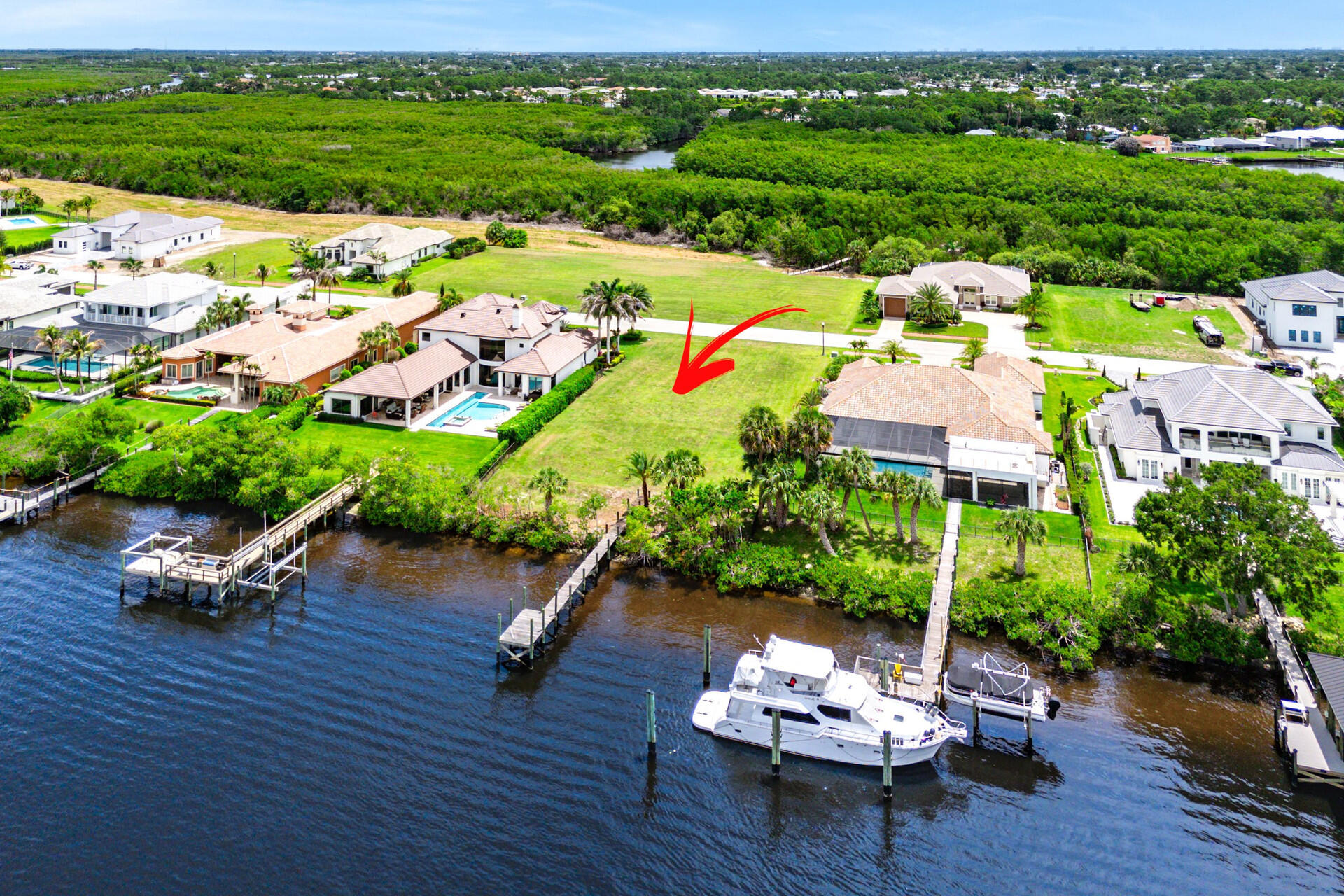 Introducing 205 SE Fiore Bello, a premier waterfront homesite in the exclusive gated community of Rivella. Spanning approximately 0.40 acres, this exceptional property offers direct water access, an existing dock already in place, and no fixed bridges for convenient boating and ocean access. One of the few lots in the community to enjoy expansive views across a natural mangrove-lined shoreline, the property offers a unique combination of privacy, natural beauty, and waterfront living.  The generously sized homesite features approximately 100 feet of direct waterfront frontage and an existing dock, providing ample space for a custom luxury residence, pool, and outdoor entertaining areas. Residents enjoy Rivella's resort-style amenities, including a clubhouse, swimming pool, fitness center, tennis courts, and scenic walking paths. Combining waterfront privacy with everyday convenience, the property is just minutes from premier golf courses, marinas, waterfront dining, shopping destinations, and the Treasure Coast's beautiful beaches.  Whether envisioned as a private waterfront retreat or a showcase custom estate, 205 SE Fiore Bello presents a rare opportunity to build in one of Port St. Lucie's most desirable luxury waterfront communities.