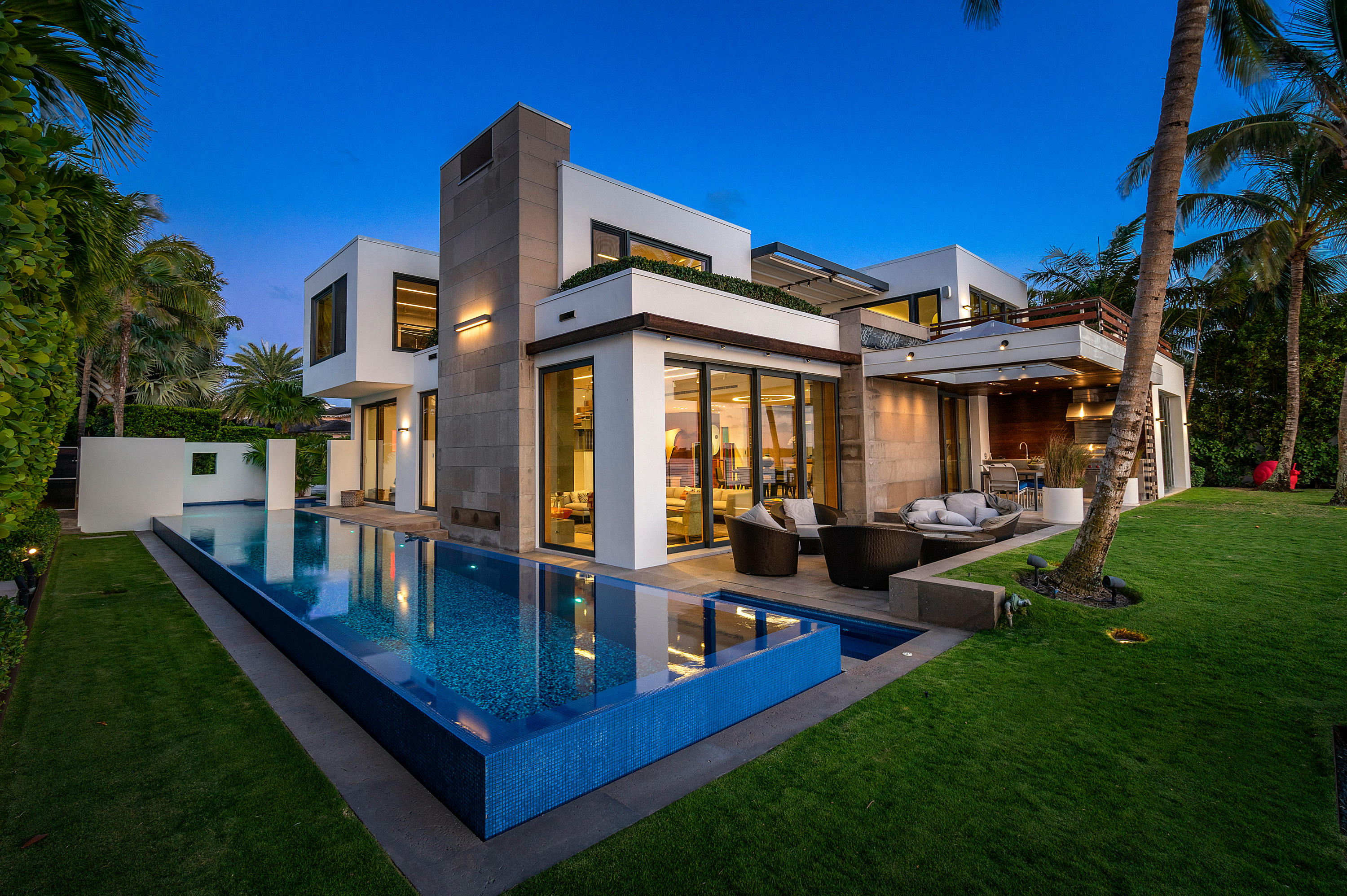 Expansive Intracoastal views from every room of this stunning 2-story Ultra-Modern Smart Home designed in 2015 by Vail architect Kyle Webb. Imagined with the purpose of enjoying indoor/outdoor living and constructed from the finest materials and finishes including wood, steel, concrete and glass to create a modern architectural symphony. Secluded behind lush landscaping and electric gates stands this elegant home featuring a front water pool streaming into the 70 foot long lap pool. The large front doors welcome you into the spacious great room facing the Intracoastal with floor to ceiling glass doors leading to a spacious deck. There you will find a complete summer kitchen, a large flat screen TV, an entertaining area, as well as the yard and the Intracoastal Waterway. The great room offers a gas fireplace, while the kitchen, designed by Bulthaup, incorporates the elements of a master chef's kitchen with a gas stove and ample counter space, plentiful storage with an area dedicated for wine, high tech lighting, and audio systems throughout. Downstairs are three bedrooms with ensuite baths, each opening onto a deck with outdoor showers and surrounded by beautiful tropical landscaping. The 2nd floor includes the main bedroom area and two offices, plus a gym reached by either an elevator or the sleek staircase of glass, steel and wood. The main bedroom doors open onto an outdoor deck, perfect for watching boats glide along the Intracoastal Waterway and enjoying the stunning sunsets. The spa-like marble master bath features indoor/outdoor bathing. This unique home combines pure luxury and sheer simplicity in a livable modern masterpiece. Ibis Isle has nighttime security and is situated across A1A from Phipps Ocean Park, the Palm Beach Tennis Center, and is very close to the Palm Beach Par 3 Golf Course. Just a short drive to Worth Avenue, fine dining and cultural centers.