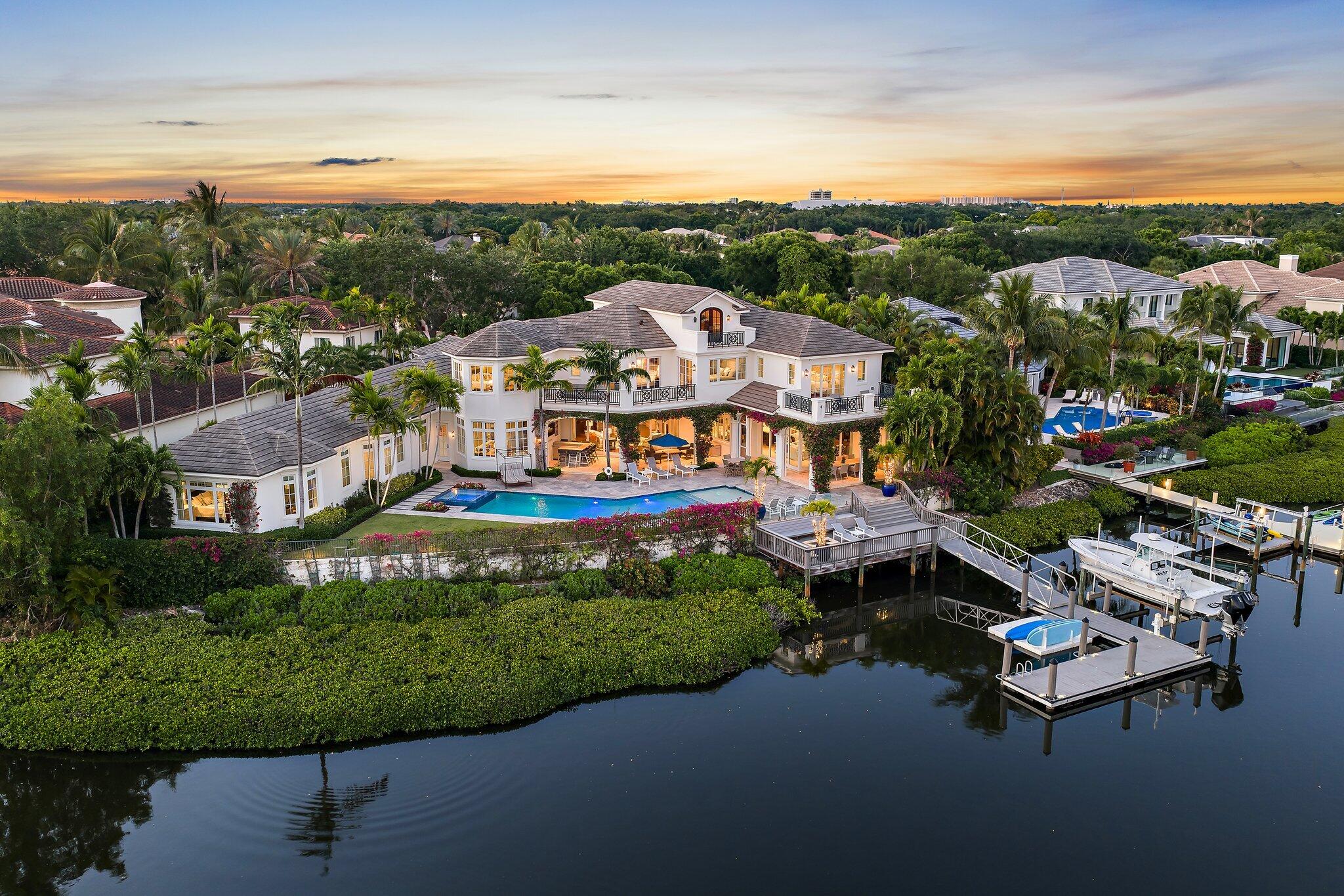 Stunning British West Indies-inspired estate set on a rare point lot, offering over 180 ft of deep, navigable waterfront and exceptional southern exposure with sweeping multi-directional views. This beautifully appointed two-story residence showcases expansive water views, elegant architectural detail, and a seamless indoor-outdoor lifestyle designed for both relaxed living and sophisticated entertaining. The home features generous living spaces, a well-conceived floor plan, and refined finishes throughout, complemented by resort-style outdoor areas, a private floating dock, and stunning vistas.  Ideally situated within one of the area's most sought-after waterfront communities, Admirals Cove, this property represents a rare opportunity to enjoy premier coastal living.   Golf Membership. Exceptionally maintained, continuously upgraded, professionally overseen luxury residence with proven quality and immediate enjoyment.     This is more than a home — it is a rare opportunity to own a property where setting, scale, and lifestyle converge at an exceptional level within Admirals Cove.  Spanning over 8,857 living sf, this residence combines timeless architecture with modern luxury and a scale rarely found in today's market.  103 Quayside benefits from continuous professional oversight and proactive updating rarely seen in luxury properties.  Better-than-new ownership experience with proven quality, meticulous care,  and major systems already refreshed  — including the recent replacement of all seven A/C units.  A partial home-features list is contained in the Documents section to this Listing.   Perfectly positioned at the end of a quiet cul-de-sac with minimal traffic, and just moments from the clubhouse, the property offers an ideal balance of serenity, accessibility, and prestige.  Designed for both grand entertaining and comfortable everyday living, the home features 9 bedrooms, 10 full baths, and 2 half baths, along with a climate-controlled 5-car garage.   The first-floor primary suite serves as a private retreat, complete with dual bathrooms and closets and a sitting area for added comfort.  An elevator services all levels.   The main living areas open seamlessly to the outdoors through fully automated glass doors in the family room that disappear at the touch of a button, creating a true indoor-outdoor lifestyle. The expansive covered lanai is equipped with integrated, concealed storm shutters and screens, designed to maintain the clean architectural lines of the home while providing protection and comfort, and flows into a resort-style setting featuring a pool and spa with dual heating systems (gas and electric), a fire pit, outdoor bar with refrigeration, and a fully equipped summer kitchen with sink and storage.    Boating enthusiasts will appreciate the 24,000-pound lift, floating dock, detachable platform, upgraded piling rings, and enhanced dock lighting — all with direct Intracoastal and ocean access and no fixed bridges.   Inside, the home is outfitted with an exceptional level of comfort and technology, including individually controlled climate zones throughout, supported by multiple compressors, a whole-house generator, water softener, leak detection system, RadioRA lighting, upgraded network and media infrastructure, and a comprehensive exterior security system. The chef's kitchen has been recently enhanced with a new island countertops, backsplash, sink, and appliances, complemented by a walk-in pantry featuring a wine chiller, refrigerator drawers, ice maker, and secondary sink.  Additional conveniences include two dishwashers and a laundry room with newer dual washer and dryer sets.   A standout architectural feature is the temperature-controlled wine room accommodating approximately 300 bottles, accessed through etched wood doors imported from Egypt — a distinctive and memorable design element.      Additional highlights include two private offices, a media room with dedicated seating, a separate playroom, multiple balconies capturing water views, and climate-controlled garage space with integrated storage systems.  An additional upper-level space provides further flexibility and potential.   This is more than a home — it is a rare opportunity to own a property where setting, scale, and lifestyle converge at an exceptional level within Admirals Cove.   A Golf Membership is available for purchase.