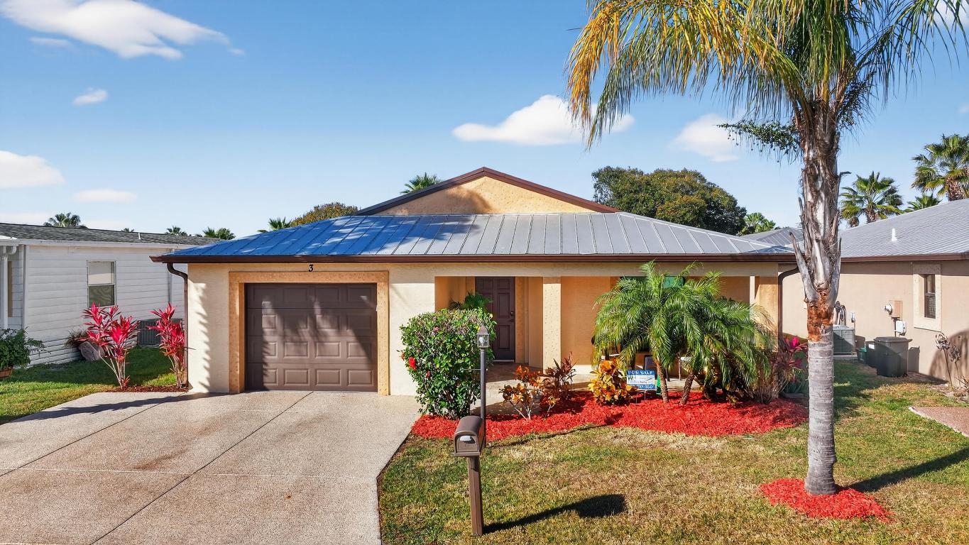 ELEGANT, DURABLE, SAFE & AFFORDABLE this 2018 2bed/2bath home w/ Only 1 owner is BUILT to LAST w/ Concrete Block Construction, IMPACT WINDOWS & a Metal Roof built over 5/8'' Plywood for maxstrength. KeyPadEntry, OpenConcept, Vaulted Ceilings,H20 Purify System throughout,LED Recessed Lights,Ceiling Fans,GRANITE Counters,Custom Window Treatmnts, StainlessSteel, Appl, 2024 Wash/Dryer, Master w/ walk-in closet & en-suite.Tiled & Shaded Front Porch & Lrg Screened, Tiled Lanai w/ Privacy Shades. Driveway coated w/ 24hour floor. PRIME LOCATION; beach, shopping,mall,grocery, bank,hospital,postal & more! Lot lease 646.36 includes trash, lawn care, Clubhouse w/Activities, Private FREE Golf,Heated Pool,Spa,Fitness,Pickleball,Tennis, Shuffleboard,Bocce,Library, Bingo,Parades, MahJong,Workshop & more!