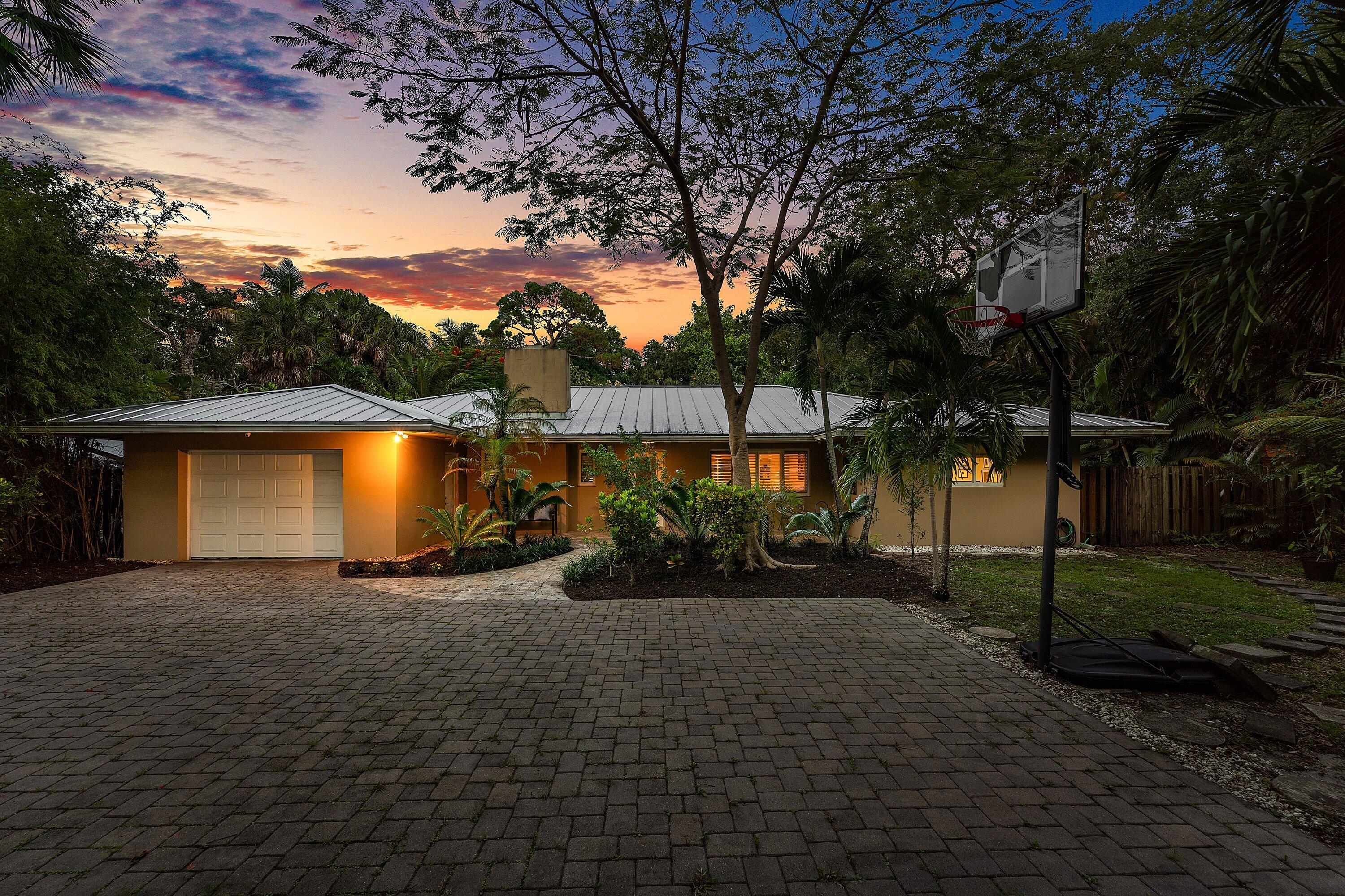 Tucked away in the hidden gem of the Riverlands, this stunning three-bedroom, three-bathroom ranch offers a rare blend of sophisticated upgrades and total seclusion. Situated on an expansive half-acre lot that backs directly onto the Riverlands Preserve, this is one of the most private residences in the community. With no neighbors behind you, the backyard serves as a serene sanctuary where you can enjoy the peace and tranquility of nature in your own tropical retreat. The interior is thoughtfully designed with a spacious split-floor plan that balances formal elegance with everyday comfort. Two distinct living areas and a formal dining room provide ample space for hosting, while plantation shutters and large impact windows allow natural light to pour across the home. The chef's kitchen is a true centerpiece, featuring sleek granite countertops, premium stainless steel KitchenAid appliances, and a generous walk-in pantry. The primary suite serves as a private escape with wood-look tile flooring and a refreshed vanity, while the guest bedrooms offer stylish epoxy flooring and the convenience of en-suite bathrooms.  Every detail has been curated for longevity and peace of mind, from the luxury metal roof and full impact glass to the new septic drain field and dual esla chargers. Outside, the lush, tropical landscaping frames a beautiful rear deck, perfect for evening refreshments while overlooking the fully fenced, half-acre grounds.  While this property feels worlds away from the hustle and bustle, it is perfectly positioned just minutes from the Fort Lauderdale airport and I-95, with the water only a block away. This is a rare opportunity to own a meticulously upgraded home in one of the few positions backing the preserve. It's more than just a house; it's a private piece of Fort Lauderdale paradise.