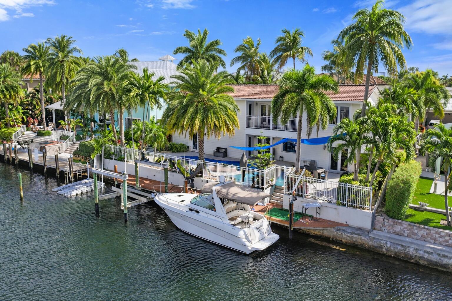 A rare opportunity and a true boater's dream with direct ocean access and no fixed bridges, this expansive two-story waterfront residence offers over 4,400 square feet of exceptional living space in the highly sought-after Venetian Isles of Lighthouse Point. The first-floor primary suite is a private retreat featuring a custom oversized walk-in closet, beautifully updated bath, and a stunning morning room with breathtaking water views. Designed for effortless entertaining, the home offers two dining areas, a custom bar with an oversized wine cooler, a modern updated kitchen with eat-in seating, a spacious living room, private office, sitting room, and a convenient half bath. Upstairs, a functional loft living space complements four generously sized bedrooms--each with impressive walk-in- closets--and two full bathrooms.   Outdoors, the South Florida lifestyle truly comes to life with a large pool surrounded by an expansive pool deck--ideal for entertaining or relaxing in total privacy. An outdoor cabana bath adds convenience, and a dedicated storage room provides ample space for boating and fishing equipment.  Hurricane-impact windows, a backup generator, and a 500-gallon underground propane tank provide added security and peace of mind. Boating enthusiasts will appreciate the 90-foot dock, boat lift, and quick access to the Hillsboro inlet and Lake Boca.  An exceptional opportunity to enjoy expansive canal-front living, generous square footage and premier boating access in one of Lighthouse Point's most desirable waterfront communities.