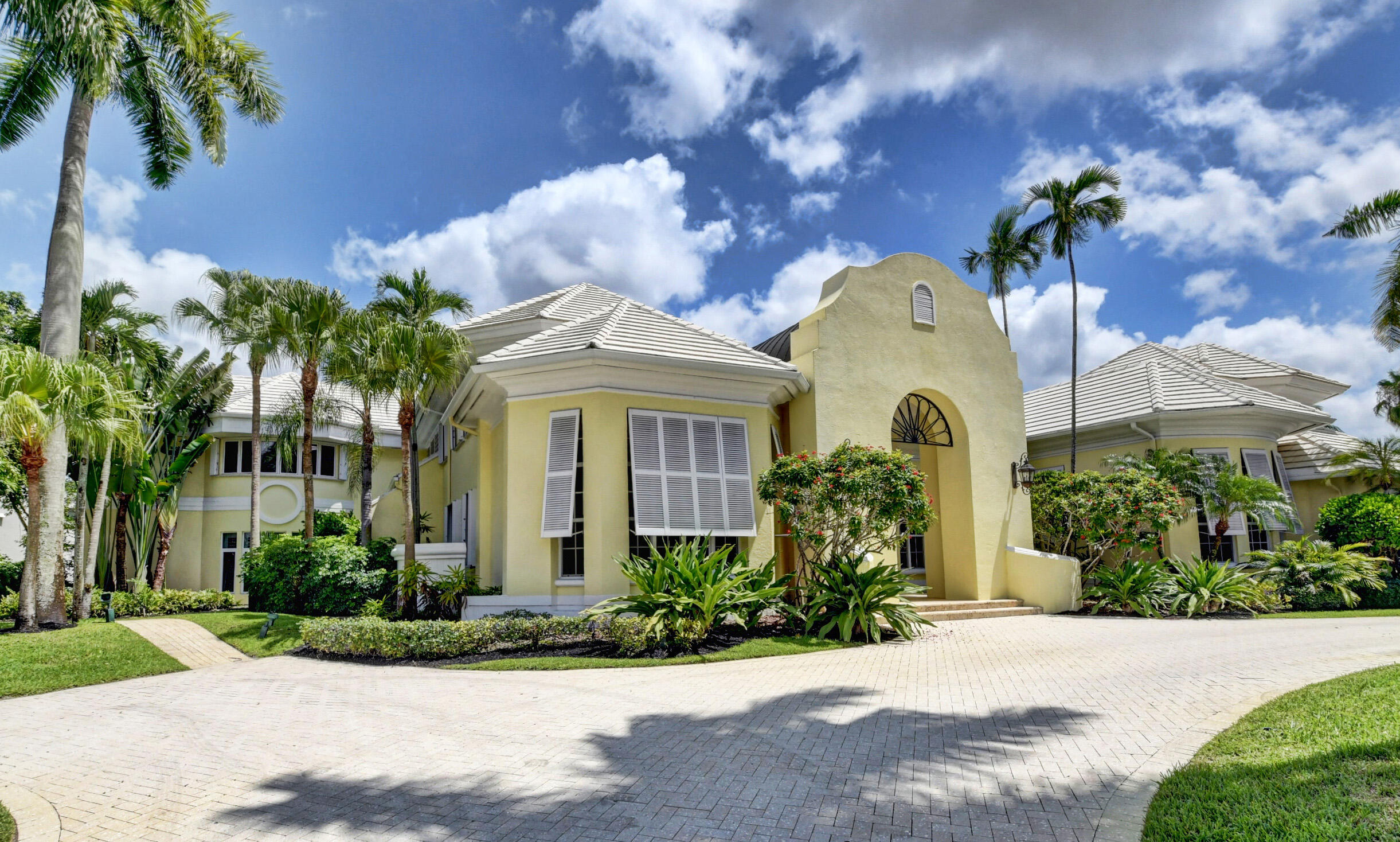 Welcome to this British colonial-inspired home on an OVERSIZED LOT (0.64 acre – almost 2x the average lot size) with Southern exposure and stunning lake views in St. Andrews CC! Open, light and bright, with volume ceilings and floor-to-ceiling windows. 6 bedrooms, a private maids quarters + office + bonus room. Large ground-level master suite with his & her baths and several custom walk-in closets. The large eat-in kitchen, with separate sitting area, features double sinks, double Viking ovens, Sub-Zero fridge & freezer, and walk-in pantry. Full hurricane protection. Outside, enjoy the Southern exposure and gorgeous lake views from the spacious patio areas, pool, spa, and sun-filled Florida room, with summer kitchen and built-in BBQ.