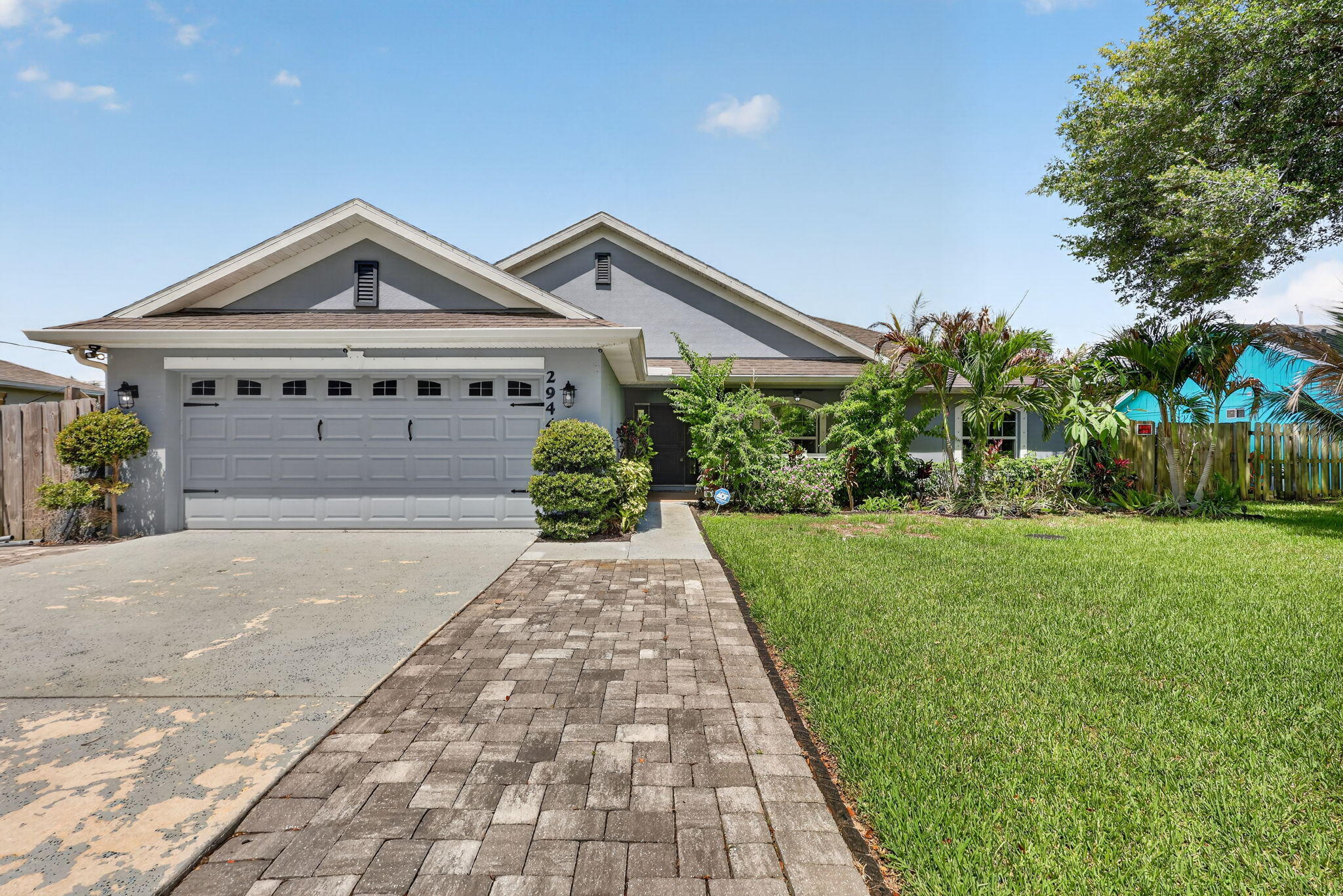 Welcome to your own slice of Florida paradise! This beautifully updated home blends modern design with warm, inviting spaces and exceptional curb appeal. From the moment you arrive, you'll appreciate the lush tropical landscaping, charming covered front porch, and welcoming entry. Inside, soaring ceilings and an open-concept layout create a bright, airy feel. The stunning kitchen features quartz countertops, custom finishes, abundant cabinetry, and a large island overlooking the spacious living area. A striking wood accent wall adds character and style, while luxury vinyl flooring flows throughout. The generous primary suite offers a peaceful retreat, and the split-bedroom layout provides privacy for family and guests. Enjoy indoor-outdoor living with plenty of room to relax and entertain.