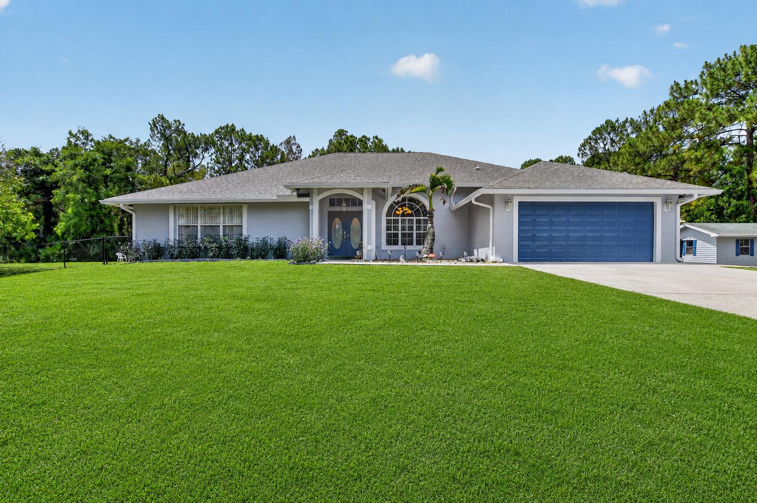 Set on a secluded 2.39-acre corner lot in the heart of Loxahatchee's Acreage community, this exceptional home offers the perfect blend of privacy, space, and freedom with **no HOA restrictions**.  Custom designed with comfort in mind, this home features 3359 sqft of spacious living, 5 generously sized bedroom en-suites creating private retreats for family members or guests. 2 additional powder rooms provide added convenience throughout the home. Dramatic 16-foot ceilings, expansive gathering areas, and abundant natural light create an inviting atmosphere. The spacious updated kitchen has granite counters, stainless steel appliances, ample cabinetry & extensive prep space. Recent upgrades include 4 updated baths & new carpets in 4 bedrooms, New roof 2020, , dual air-conditioning systems replaced in 2024, a new water heater installed in 2025, whole-house reverse osmosis filtration with a 500-gallon storage tank, New 2025 accordion hurricane shutters, fresh exterior paint completed in 2026, new well pump in 2025, and an 8 camera security system with live monitoring capability. The property also offers an oversized crushed-asphalt parking area accommodating approximately 12 vehicles, along with dedicated space for RV, trailer, and boat storage. Additional features include a 15' x 30' storage building, screened pool enclosure, and a highly desirable corner location with frontage on two paved roads. Outdoor living takes center stage with a screened, solar-heated saltwater pool surrounded by an expansive covered lanai and entertainment area. Recently refinished in August 2025, the fiberglass pool features updated paver surround,  and a relaxing hot tub, creating a true backyard retreat. Multiple ceiling fans enhance year-round comfort, making this an ideal setting for gatherings or peaceful evenings at home. Pet owners will appreciate the convenient dog door providing direct access to approximately one acre of fenced outdoor space, offering plenty of room for pets to roam safely.  Living in The Acreage offers a unique lifestyle with room for recreational vehicles, boats, workshops, and animals, all without the restrictions and fees commonly associated with HOA communities. Despite its peaceful country atmosphere, the property is conveniently located near shopping, dining, schools, parks, golf courses, equestrian facilities, and the rapidly growing communities of Westlake and Palm Beach Gardens. The area's natural beauty, wide-open spaces, and strong sense of community make The Acreage one of Palm Beach County's most desirable places to call home.   **** SOME PHOTOS HAVE BEEN STAGED AND STAGED FOR POTENTIAL REMODELS****