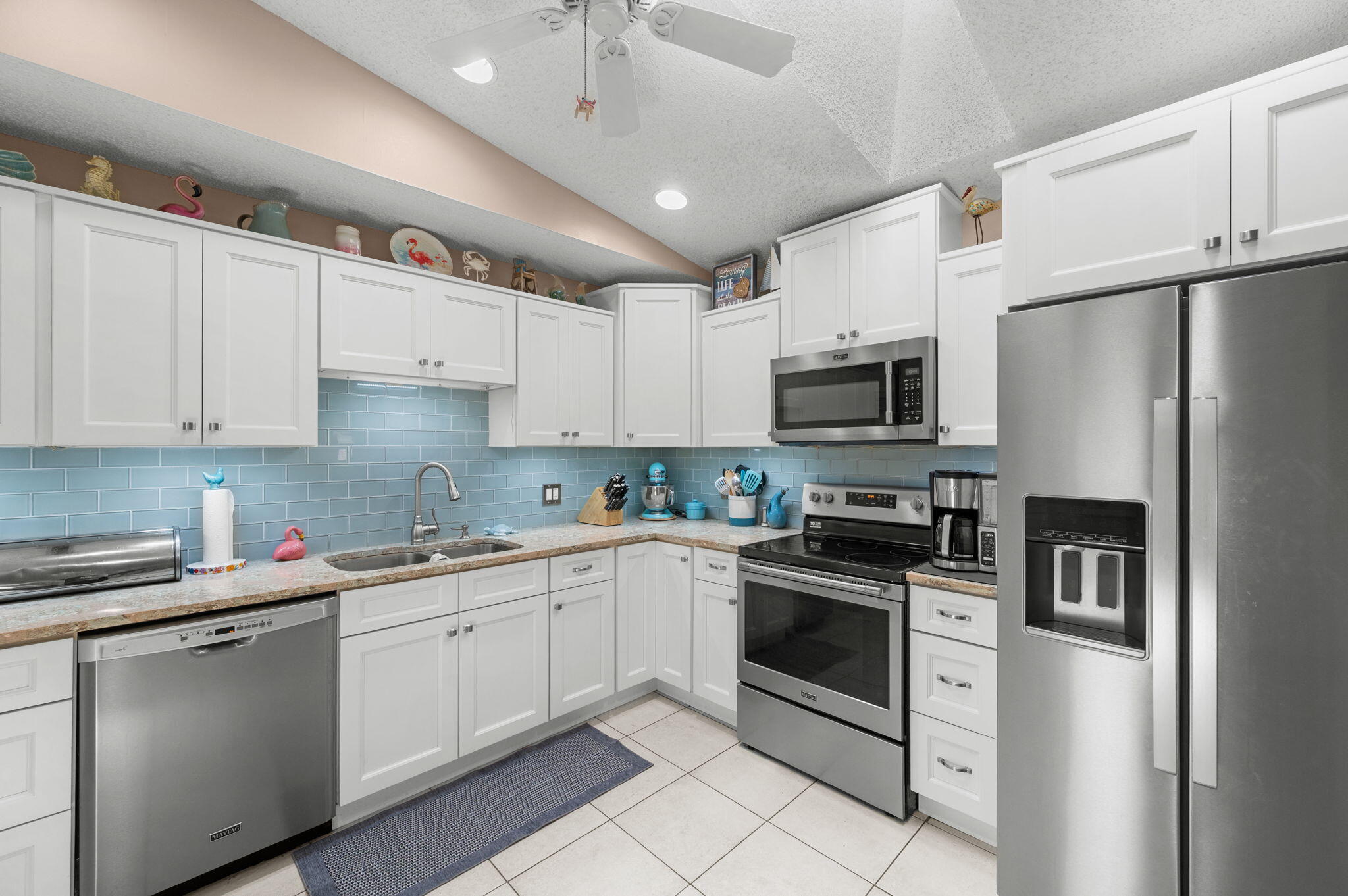 Move-in ready 2BR/2BA villa featuring a rare oversized 1.5-car garage and 570-sq-ft screened lanai. Enjoy peace of mind with a newer roof (2021), HVAC (2021), and water heater (2018). The remodeled kitchen showcases stunning quartz countertops, updated cabinetry, pantry, and newer stainless steel appliances, opening seamlessly to the living and dining areas. The spacious primary suite was renovated in 2024 and features luxury viny plank flooring,  a walk-in closet, and a beautifully updated en-suite bath. A split-bedroom floor plan offers privacy for guests, while plantation shutters throughout add timeless style. In-unit washer/dryer, accordion hurricane shutters, and ample storage. Residents enjoy two pools (one geothermal heated and cooled year-round), a clubhouse, and lawn care.