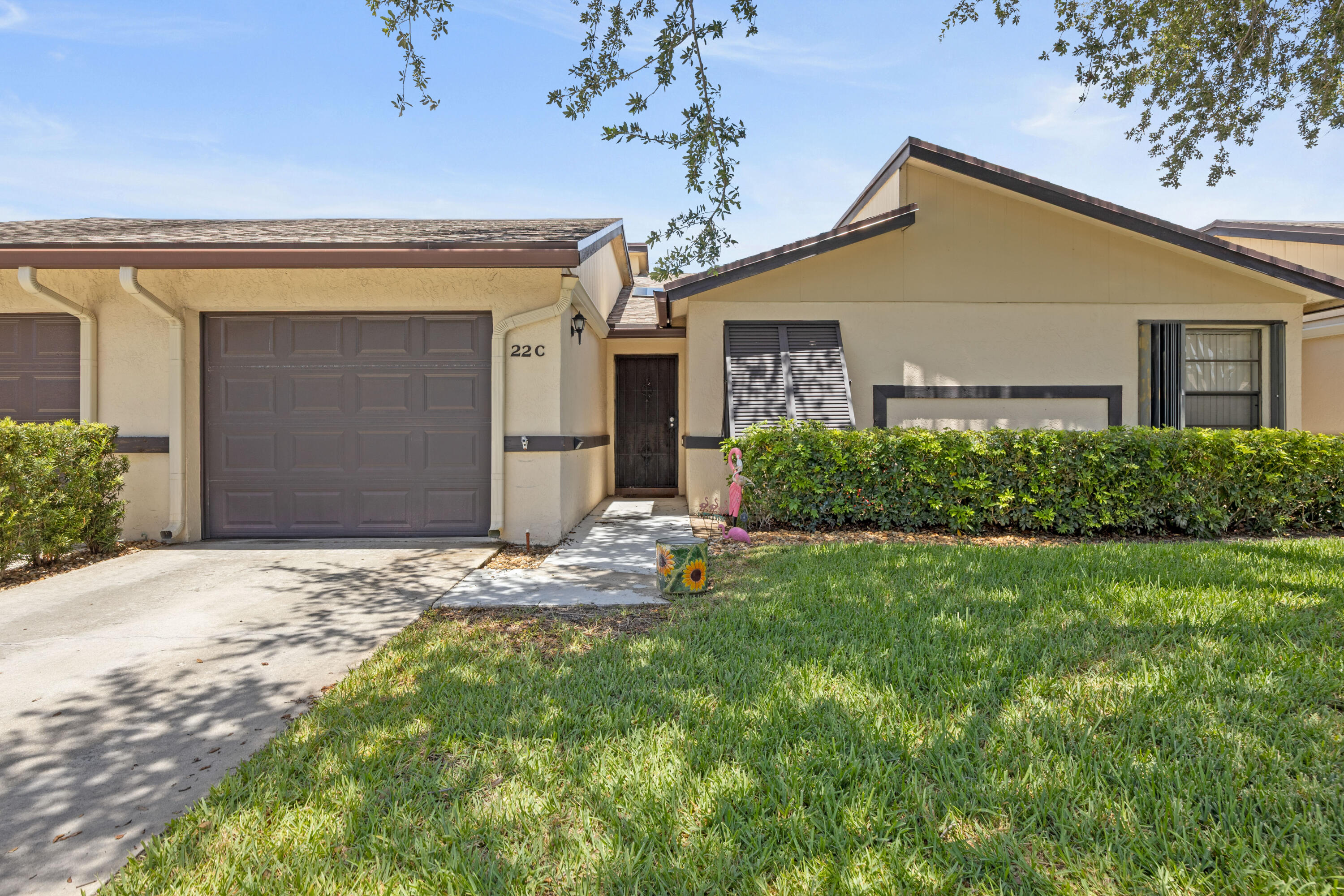 Ridgepointe Woods Villas—one of Boynton Beach's best-kept secrets! Ideally located in East Boynton Beach near beaches, restaurants, shopping, and I-95, this spacious 2BR/2BA villa with a 1-car garage offers vaulted ceilings, tile flooring throughout, and plantation shutters in the living room. A newer roof (2019) with skylights fills the home with natural light. The desirable split floor plan features a guest bedroom and bath near the entry, while the primary suite offers a large walk-in closet, separate vanity area, and step-in shower. The enclosed lanai provides flexible living space for an office or guests and opens to a large paver patio overlooking a peaceful green space. HVAC replaced in 2021. Electric shutters in rear. Pull down stairs for attic access. A rare find in East Boynton  HOA covers building insurance, exterior maintenance, roof maintenance, water, internet, cable, community pool and small clubhouse perfect for card games and social activities.