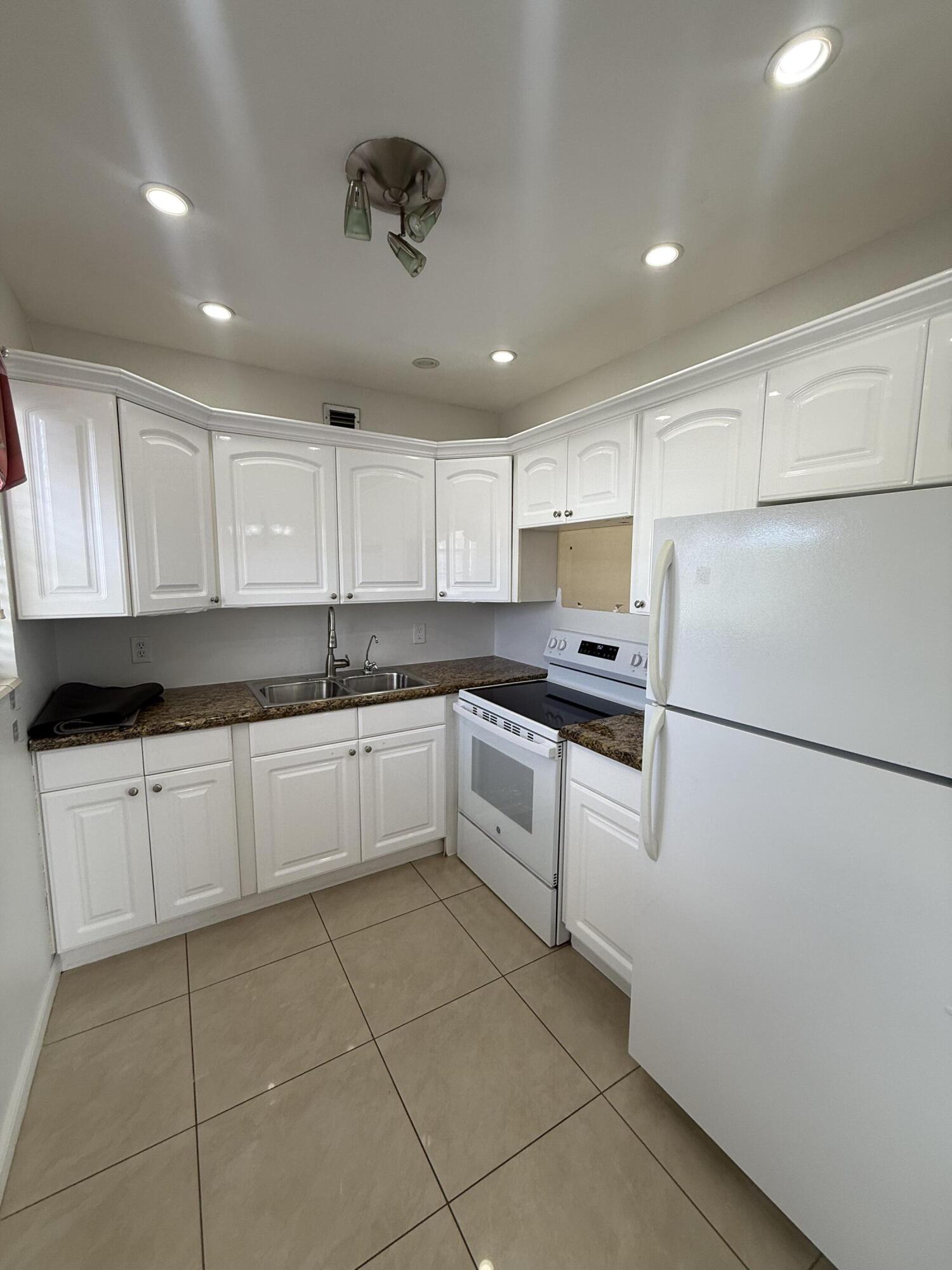 Enjoy easy, low-maintenance living in this desirable furnished second-floor corner unit featuring 2 bedrooms and 1.5 baths, located in a gated 55+ community. This well-maintained home offers tile flooring throughout and updated bathrooms, creating a clean, modern feel. The updated kitchen features white cabinetry, recessed lighting, and a new microwave oven. Step outside to your private balcony—perfect for relaxing and unwinding at the end of the day. The balcony overlooks peaceful green space. Residents enjoy resort-style amenities, including a 1,000-seat theater for shows and movies, indoor and outdoor pools, a courtesy shuttle bus, and a wide variety of social activities and events. Conveniently located near Palm Beach International Airport, popular restaurants, shopping, and  the beautiful beaches of Palm Beach, this community offers both comfort and convenience in an ideal South Florida location.