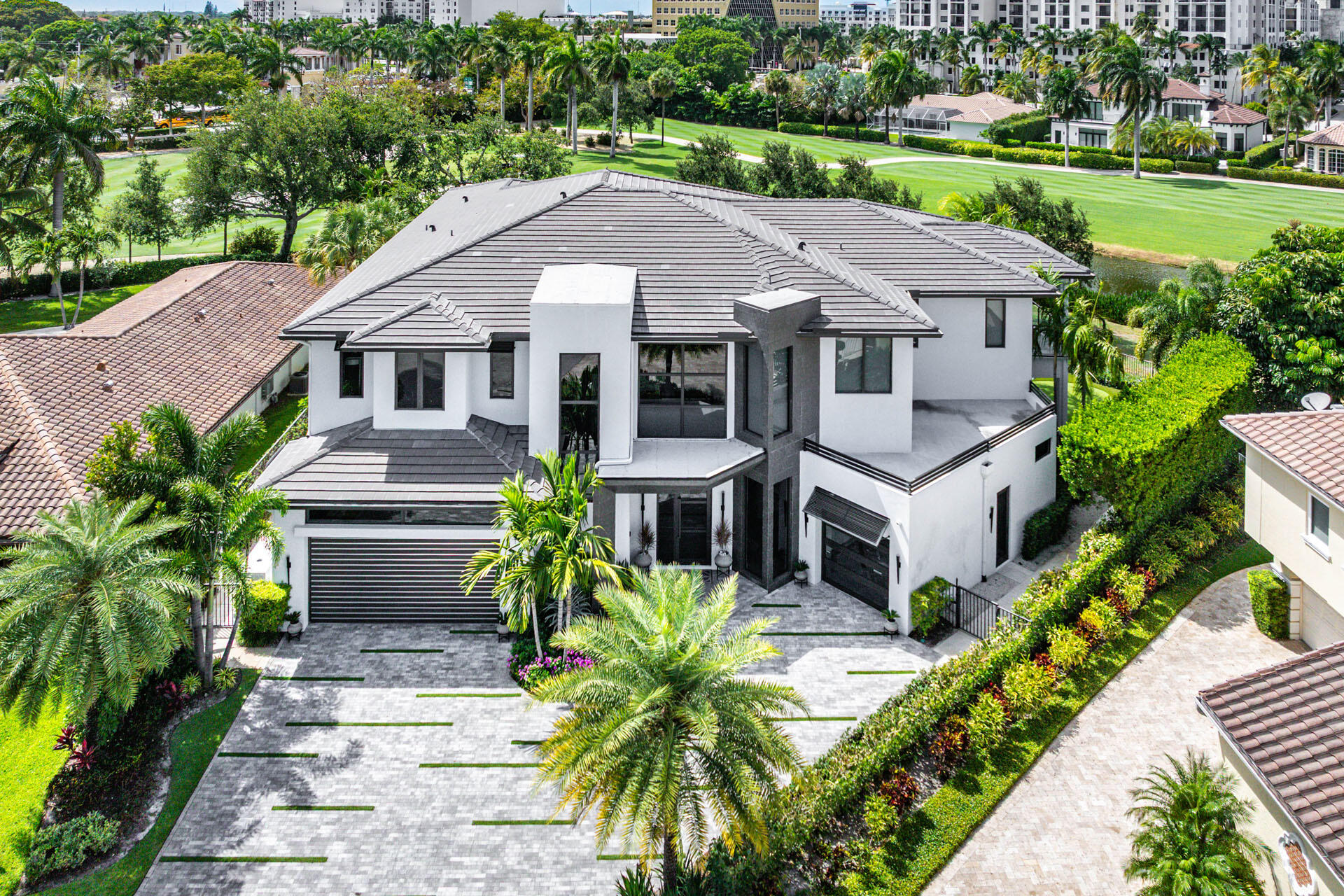 Welcome to 117 Thatch Palm Cove, located on the quietest cul-de-sac street in the prestigious Royal Palm Yacht & Country Club. Built in 2023 by Primo Construction, this golf course estate offers 165 feet of prime golf frontage with sweeping views of a serene pond and the Jack Nicklaus signature golf course, and features over 7,700 square feet of luxurious living space with 5 bedrooms, 6 baths, and a club room. Floor-to-ceiling glass brings in ample natural light and perfectly frames the tranquil water and golf views, creating a seamless connection between the chef's kitchen, family room, great room, and the resort-style outdoor area with heated pool, spa, covered seating, and lush landscaping.  Additional highlights include a private putting green, full-house generator, and a three-car garage, one of which is an incredible show garage designed to showcase a prized automobile.