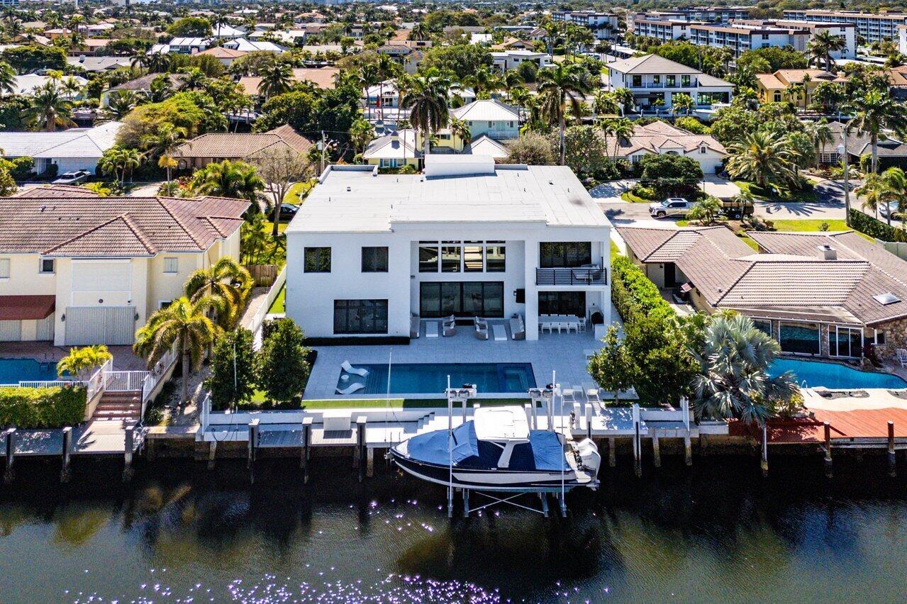Experience the epitome of luxury waterfront living in Delray Beach's prestigious Tropic Isle! This magnificent home boasts a modern design with stunning Intracoastal water views from every room. Featuring a 90-ft boat dock with a new lift that accommodates up to 40,000 lbs, Impact Windows, Generator. Offering 4 bedrooms, plus an office, gym, club room, and 5 1/2 baths, every corner is designed with sophistication. Floor-to-ceiling windows flood the home with natural light, enhancing the open and airy feel. The gourmet kitchen is a chef's dream, equipped with premium appliances, custom cabinetry, and a spacious island. The master bath is a true retreat, and the summer kitchen, Sonos smart integration, custom bar, and resort-style heated pool with sun shelf and fireplace ensure effortl relaxation and entertainment. Custom closets throughout provide ample storage, while the unbeatable location allows you to use your golf cart to reach the beach or Atlantic Avenue, and walk to nearby shopping and dining. This home is perfectly designed for unforgettable gatherings, with every detail meticulously curated for the ultimate living experience.