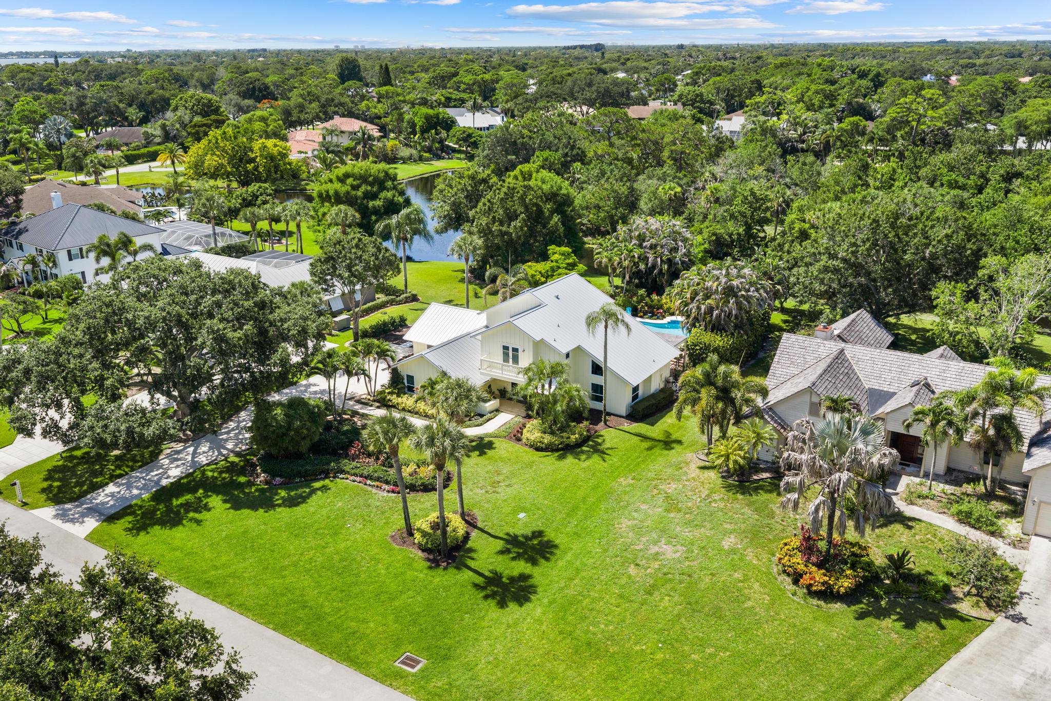 If you've been looking for that perfect spot in Jupiter where you can actually stretch out and breathe, this is it. Tucked away in desirable Whispering Trails, serenity and privacy are yours.  This 1/2 acre lakefront lot is one of the finest in the community, with lake and preserve island views and mature tropical foliage where regular visitors include herons, Roseate spoonbills, and plenty of largemouth bass. The 4 bedroom, 3.5 bath home has been cared for by the same owners since 1999.  Complete hurricane impact windows and doors 2018, standing seam metal roof 2018, pool built in 2001 and resurfaced 2018.  The upper level master suite offers a custom bath with steam shower and a private deck overlooking the pool and lake.  One guest bedroom upstairs, the other two on the main level.   2 AC units, installed 2018 and 2022
