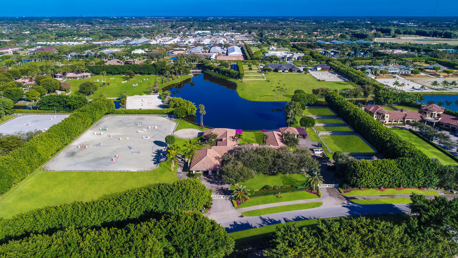 A RARE OPPORTUNITY! Situated on 6 tranquil acres, Turnabout Farm is an equestrian masterpiece located in the enclave of Grand Prix Village proper. A peaceful oasis just steps from the show grounds, with stunning water views and beautiful mature Ficus and Oak trees. Fully renovated in 2015, the 18-stall barn boasts large windows, a main lounge/tack room with office, two additional tack rooms, wash stalls and ample storage areas. There are four additional custom stalls under the trellises, four spacious paddocks, and a new state-of-the-art Kraft 6-horse walker with irrigated center round pen. The field and 180' x 280' all-weather arena were upgraded in 2019, with full drainage systems throughout, premium footing, new fencing and irrigation systems. Turnabout Farm is truly horse heaven.