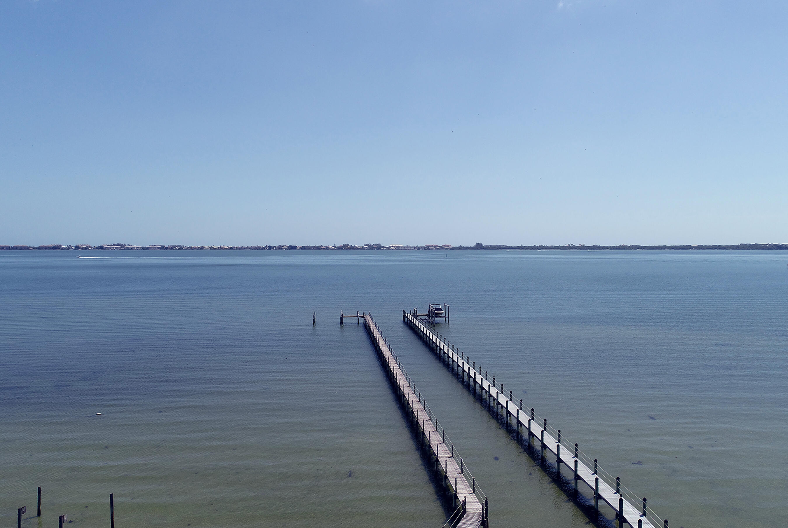 Rare opportunity to own nearly 1 acre (.9 acres) on the wide waters of the Indian River Lagoon/Intracoastal Waterway. This private waterfront estate offers endless possibilities to renovate, reimagine, or build your dream home on one of the area's most desirable waterfront homesites. A long driveway leads to this 2-story, 4936 sf under air, 6 BR, 4 BA residence and separate 3-car garage, while a walled front entry enhances privacy. Inside, soaring 20+ ft ceilings, a dramatic double-sided fireplace, wet bar, vaulted wood ceilings, French doors, and expansive water views create an impressive setting. The floor plan includes a first-floor primary suite with private waterfront deck and hot tub, spacious guest accommodations, loft/family room, multiple decks,  (see supplement) and abundant storage. Enjoy a pool, NEW seawall, private dock, NEWER metal roof on main house, and breathtaking wide water views. An exceptional opportunity to create a spectacular waterfront estate in an irreplaceable Intracoastal location.