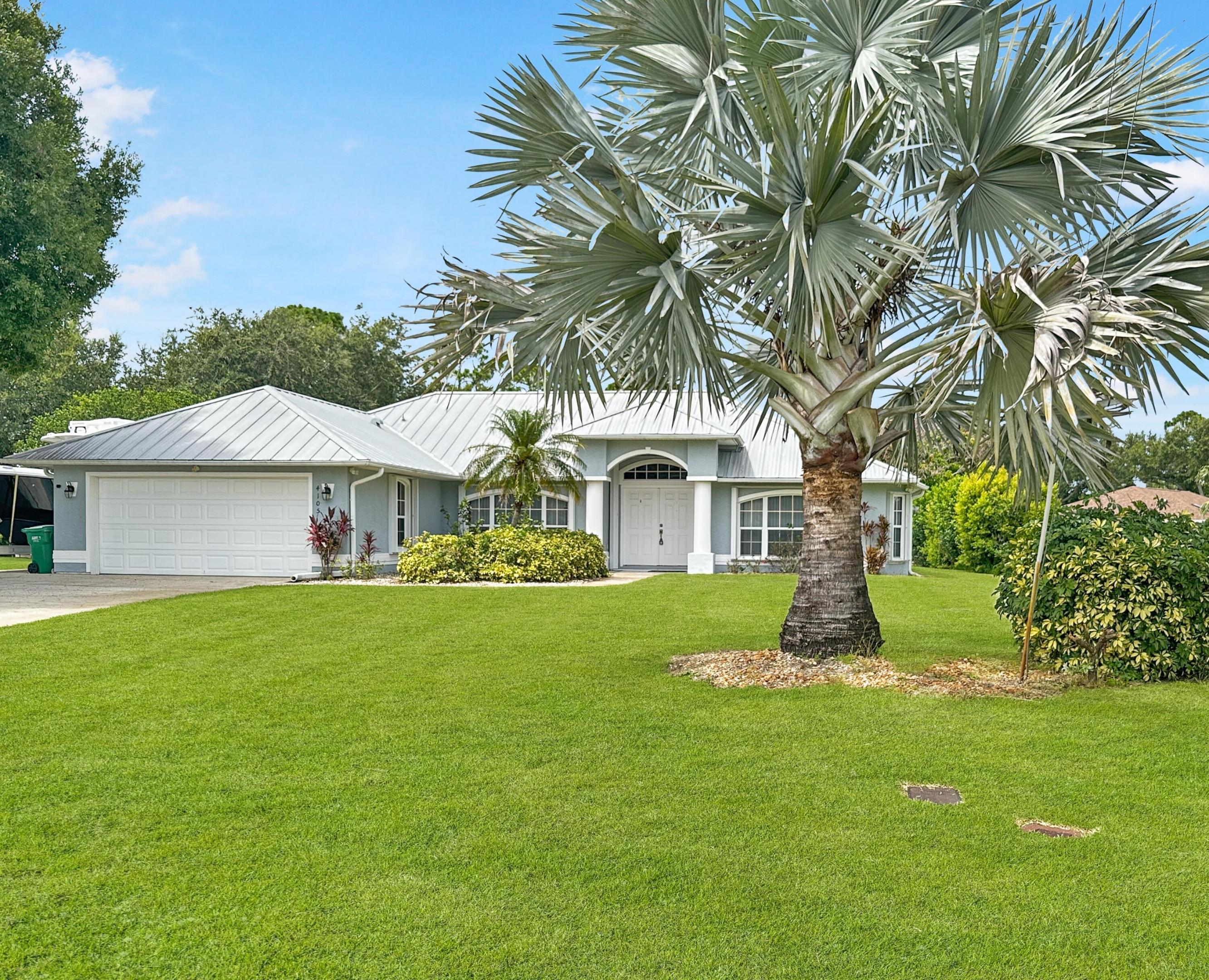 Welcome to a stunning retreat perfect for families seeking space, comfort, and versatility in a desirable neighborhood in northern unincorporated St. Lucie County. Set on a generous .65-acre lot on a quiet cul-de-sac, this beautifully maintained 2003 CBS home offers three spacious bedrooms and a thoughtfully designed split floor plan. Step inside to an elegant entryway that leads to an inviting living room, where triple sliders disappear seamlessly into the wall, blurring the line between indoor and outdoor living. Entertain in style in the formal dining area or enjoy casual meals in the cozy breakfast nook overlooking the sparkling screened-in pool. The modern kitchen is a chef's delight, boasting a large walk-in pantry, plenty of countertop area and pool views. Retreat to the grand master suite with a roomy walk-in closet, a luxurious bath featuring a garden tub, spacious walk-in shower and private pool access. The two guest bedrooms each offer walk-in closets and the guest bath serves as a cabana bath with direct entry from the pool.  Outdoors, relax by the heated pool with a tranquil waterfall feature or enjoy a morning coffee on the covered porch. A massive outbuilding with a workshop, mini split A/C, 2 oversized overhead garage doors, a separate pedestrian door entrance and a half bath, offer endless possibilities—perfect for hobbies, and RV/boat/trailer/etc. storage. With an expanded driveway, RV electric and sewer hookups, and ample land, this property combines everyday convenience with space to grow.  Accordion shutters and a 2012 metal roof provide peace of mind for any inclement weather. All this, just minutes from schools, shopping, dining, golf, parks, beaches, and major roadways—your family's perfect Florida lifestyle awaits!