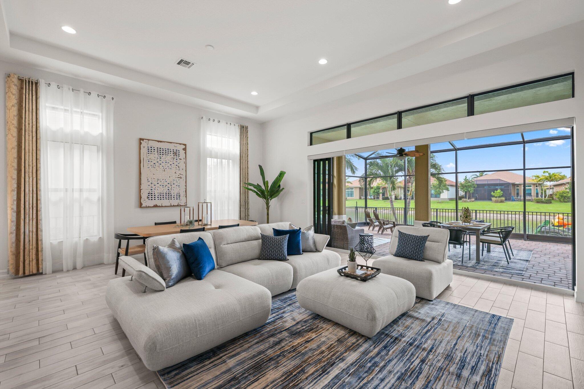 Experience luxury active-adult living in Four Seasons at Parkland! Situated on a premium waterfront lot with desirable north-south exposure, this stunning contemporary residence offers 2,601 square feet of beautifully appointed living space. Designed with exceptional attention to detail, the home features high-end finishes throughout, a whole-house generator, and customized closets.  The gourmet kitchen is a chef's dream, showcasing a huge center island, premium cabinetry, and abundant workspace, all flowing seamlessly into the expansive great room—perfect for entertaining. Sliding doors open to an extended screened lanai overlooking tranquil water views, creating the ideal indoor-outdoor lifestyle.  SEE SUPPLEMENT REMARKS... The spacious primary suite is a private retreat with a spa-inspired bathroom and custom-designed closets. Additional living spaces include a guest bedroom ensuite, private office/den, and versatile flex room to fit your lifestyle needs. The fenced backyard provides added privacy and room to enjoy the beautiful waterfront setting.  Enjoy resort-style 55+ living in one of Parkland's most sought-after communities, close to world-class amenities, dining, shopping, and recreation.