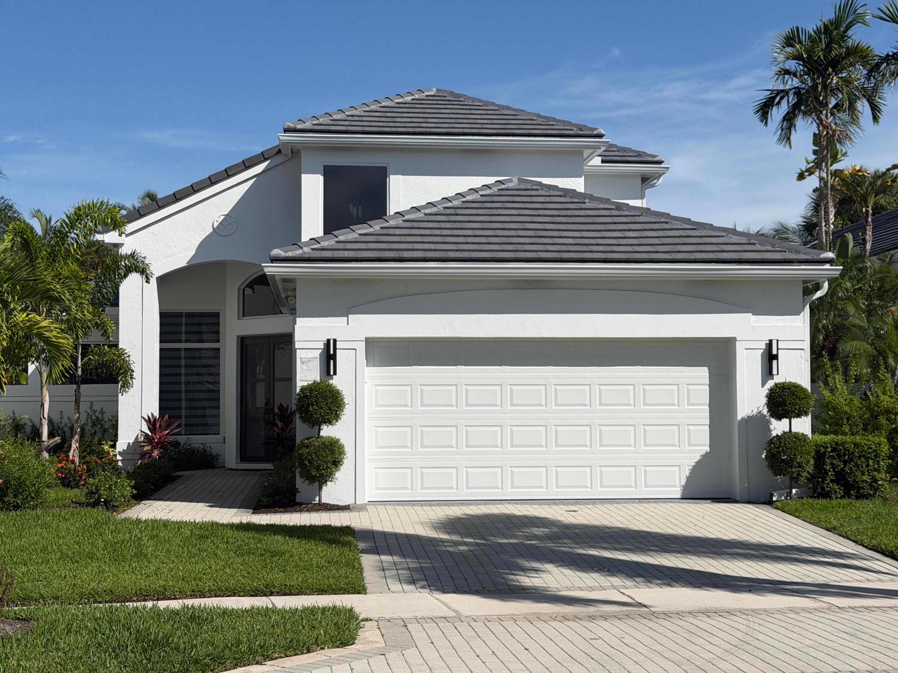 Experience the luxury of a completely reimagined home with every detail redesigned from the roof & windows to the remarkable interior.Nestled on a private interior lot, this spectacular 2-story residence with 3 bedrooms & 2½ baths provides the feel of brand-new construction. Soaring volume ceilings with LED lighting,skim-coated walls & ceilings,white polished 24" x 48" Italian rectified porcelain tile floors downstairs,light oak engineered wood upstairs,and a stunning staircase with tempered glass & a black aluminum railing create an unforgettable first impression.Custom zebra shades and raised solid-core doors enhance the home's contemporary aesthetic.The gourmet kitchen is a true showpiece,featuring white 42" upper cabinets with quartz counters & maple interiors and roll-out shelving,  taupe wood lower cabinets,porcelain tile backsplash,and premium Thermador stainless steel appliances. The elegant Primary Suite is accented by custom contemporary wall moldings. Virtually every major component of the home has been replaced, including the roof & gutters, impact windows and doors (except for 3 glass block windows), impact garage door, 2 new HVAC systems with all-new ductwork, water heater, plumbing lines & Hansgrohe plumbing fixtures, electrical panel in the garage, attic insulation, California Closets throughout, epoxy garage floor, and Electrolux Titanium washer and dryer. Outside, a completely private all-new backyard retreat awaits with hedging, marble paver patio, and premium maintenance-free turf—perfect for relaxing or entertaining. Nothing has been overlooked. Simply unpack your toothbrush and begin enjoying a home that offers style, quality, and peace of mind. This is a truly rare opportunity not to be missed.