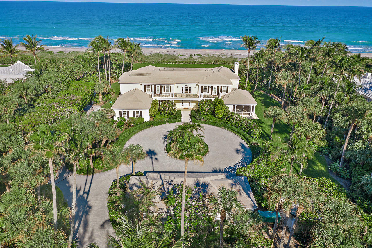 This spectacular oceanfront property sits directly on 187 feet of prime Jupiter Island beach frontage. The high elevation with deep and wide emerald green lawn offers unobstructed panoramic views of the turquoise Atlantic. The spacious, classic residence includes five bedrooms each with its own en-suite bathroom and enormous closets. There are numerous entertaining rooms all with ocean views to accommodate many family members and guests.  Five car garage space.