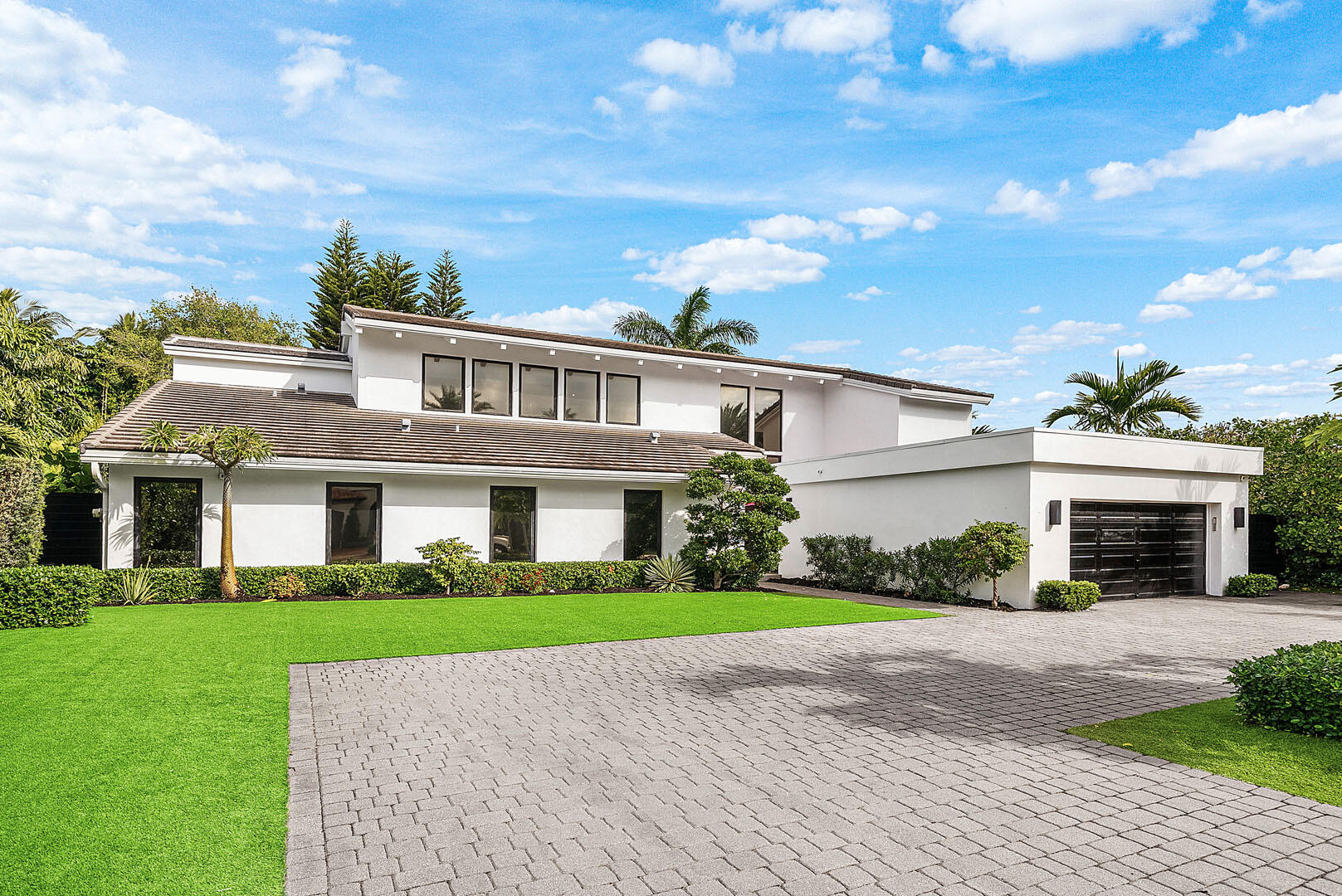 A refreshed two-story mid-century modern residence, this home is defined by dramatic vaulted wood ceilings, warm architectural character, and an effortless sense of style across just over 4,000 square feet of living space. Designed for both everyday comfort and elevated entertaining, the layout offers four spacious bedrooms and four-and-a-half beautifully appointed baths. At the heart of the home, a gourmet eat-in kitchen features a striking center island and premium appliances, creating a natural gathering place for family and guests alike. A glass-enclosed study overlooks the shimmering pool, offering a serene workspace framed by views of the backyard oasis. Step outside to a private retreat where a custom heated pool and spa invite year-round enjoyment, complemented by an outdoor shower and low-maintenance turf landscaping. The covered patio is perfectly arranged for al fresco dining and relaxed lounge seating, delivering the ideal indoor-outdoor lifestyle. The primary suite is a true sanctuary, complete with a spa-inspired bath and dual walk-in closets. Additional highlights include natural gas service, a generator, and impact glass throughout providing comfort, security, and peace of mind in a residence that feels both timeless and perfectly updated.