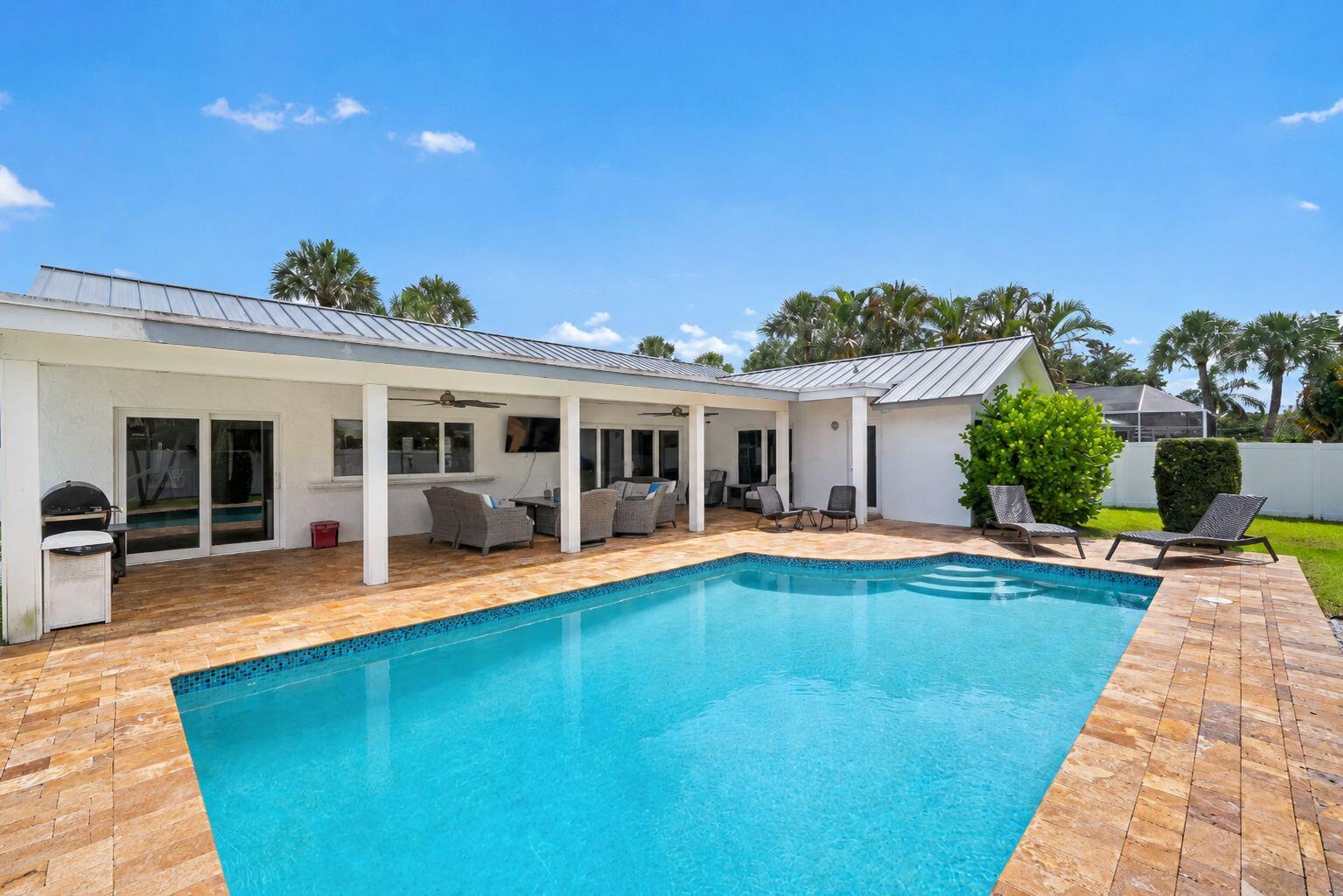 Situated in the highly desirable Palm Beach Farms neighborhood of East Boca Raton, this charming single-story residence offers 3 bedrooms plus an office, 2 bathrooms, and a spacious open-concept floor plan. The kitchen flows seamlessly into the family room and dining area, creating an inviting setting for everyday living and entertaining. Interior highlights include plantation shutters, an indoor laundry room, and abundant natural light. Enjoy South Florida living with a large fenced backyard featuring lush green space, a swimming pool, and covered outdoor entertaining area. Recent upgrades include a metal roof (2022), impact windows and doors, new refrigerator, new pool pump, and privacy fence. Located just minutes from Mizner Park and Boca's beaches. Situated within the highly desirable Palm Beach Farms neighborhood of East Boca Raton, this charming single-story residence offers the perfect blend of comfort, style, and convenience. Featuring 3 bedrooms plus a dedicated office, 2 full bathrooms, and an ideal open-concept layout, the home seamlessly connects the kitchen, family room, and dining area, creating an inviting atmosphere for both everyday living and entertaining. Additional interior highlights include plantation shutters throughout, an indoor laundry room, and an abundance of natural light.  Designed for effortless indoor-outdoor living, the property boasts a large backyard with lush green space, a swimming pool, and a covered outdoor area perfect for relaxing or hosting guests year-round. The grounds are fully fenced with a six-foot privacy fence and enhanced by landscaping, creating a private backyard retreat.  Recent improvements provide peace of mind and modern functionality, including a metal roof installed in August 2022, complete impact windows and doors, a new privacy fence, new refrigerator, and new pool pump.  Additional highlights include a spacious two-car garage and an exceptional location just minutes from Mizner Park, Boca Raton's pristine beaches, I-95, world-class shopping and dining, and multiple international and private airports. Combining the charm of Palm Beach Farms with modern upgrades and a prime East Boca location, this exceptional residence presents an outstanding opportunity to enjoy the very best of the South Florida lifestyle.