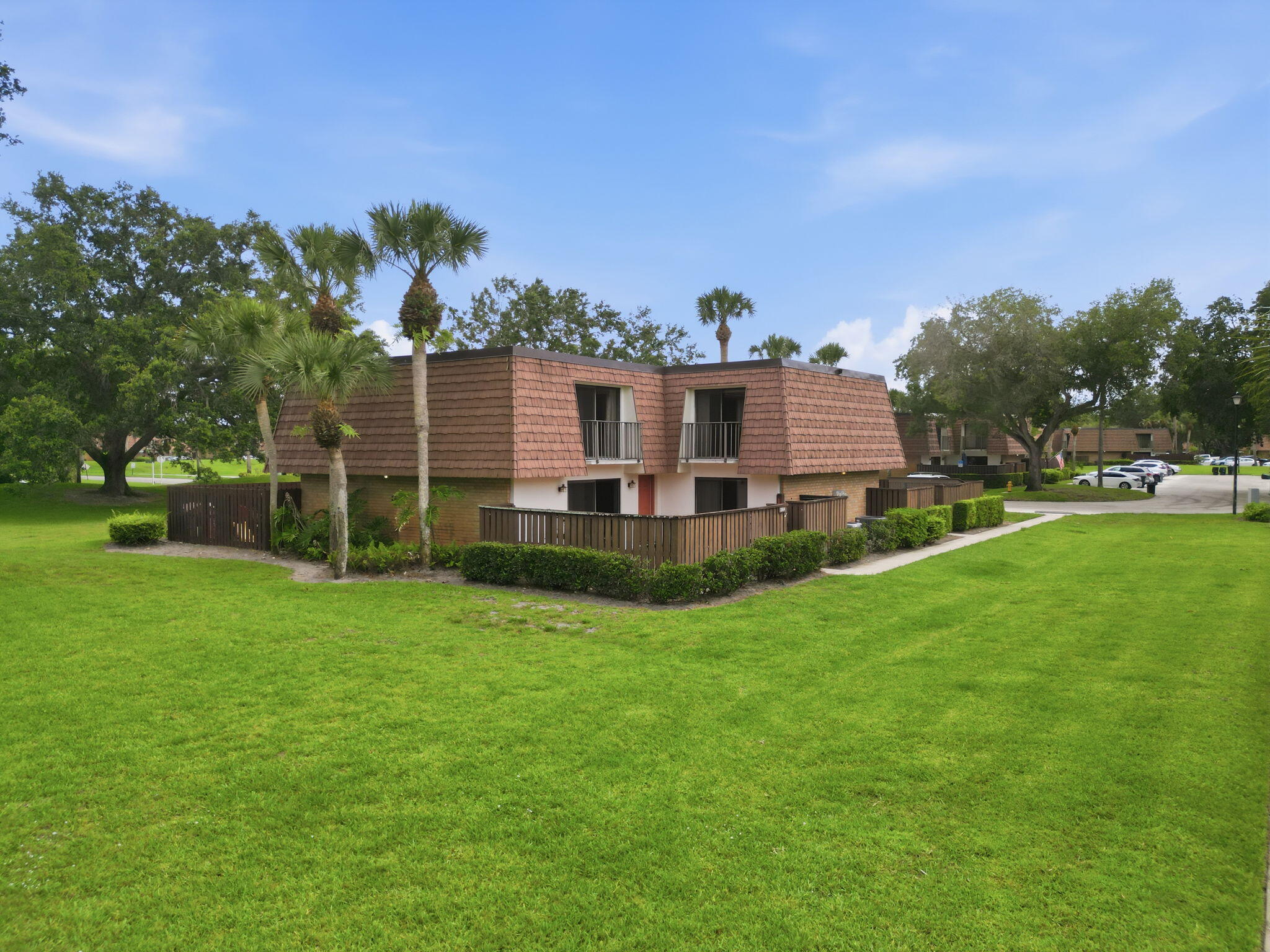 Welcome home to this well-presented 2-bed, 2.5-bath townhome, located just inside the gated community entrance for ultimate convenience and only minutes from the Turnpike. Pet owners will especially appreciate the expansive green space directly outside the gate. The ground floor offers a spacious living room, kitchen, dining area, half bathroom with laundry, and a practical under-stairs storage space. The well appointed kitchen provides modern, traditional wooden cabinetry, Granite counters with a snack bar and stainless steel appliances. Sliders to the courtyard from the kitchen and living room. Upstairs, you'll find two generous size ensuite bedrooms, both featuring ample closet space (master walk-in) and charming Juliet balconies overlooking the tropical green space.  Thoughtful recent updates include luxury vinyl flooring in both bedrooms, new stair carpeting, built-in closet systems, a newer washer and dryer, paint and lightly refreshed bathrooms. Step outside and enjoy the Florida lifestyle year-round from your own private, fenced 25' x 18' courtyard — perfect for relaxing, entertaining, or giving your pets extra room to roam. Additional benefits include two assigned parking spaces, a 2021 HVAC system, and a 2020 hot water heater. Residents also enjoy onsite amenities including tennis courts, basketball, 2 community pools, and a children's play area currently undergoing refurbishment.  Adding even more convenience, the current owners regularly walk to nearby restaurants just across the street. No catch — this move-in-ready home is available for immediate occupancy!